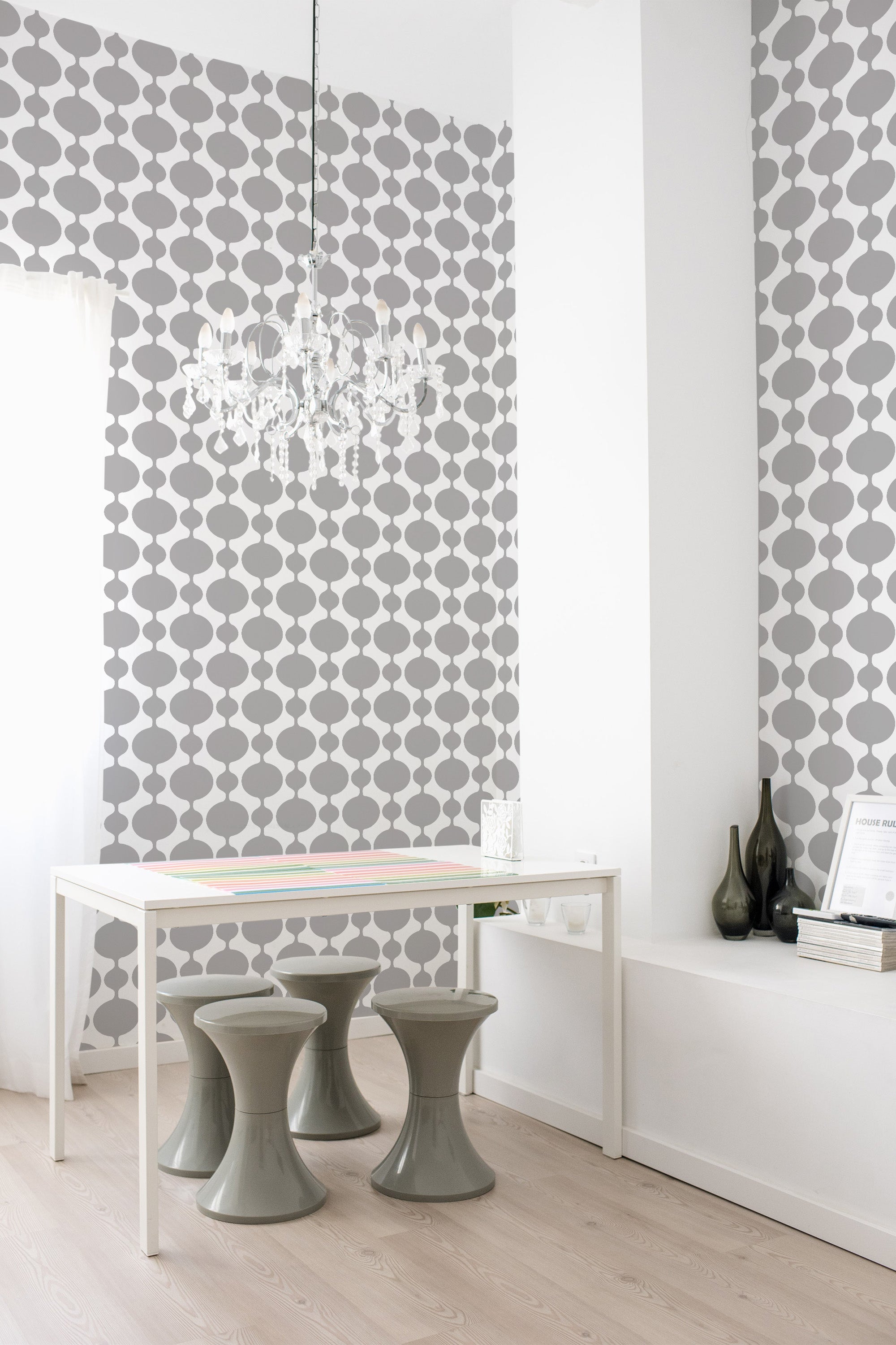 A room with wallpaper illustrating a simple geometric pattern of interconnected gray circles in vertical rows on a white background, creating a minimalist and vintage aesthetic. Traditional wallpaper.