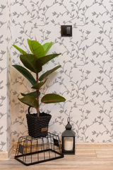 Self-adhesive wallpaper with a seamless tree design, showcasing delicate gray branches and leaves on a light beige background. The pattern spreads consistently, giving a natural, serene feel to the room.