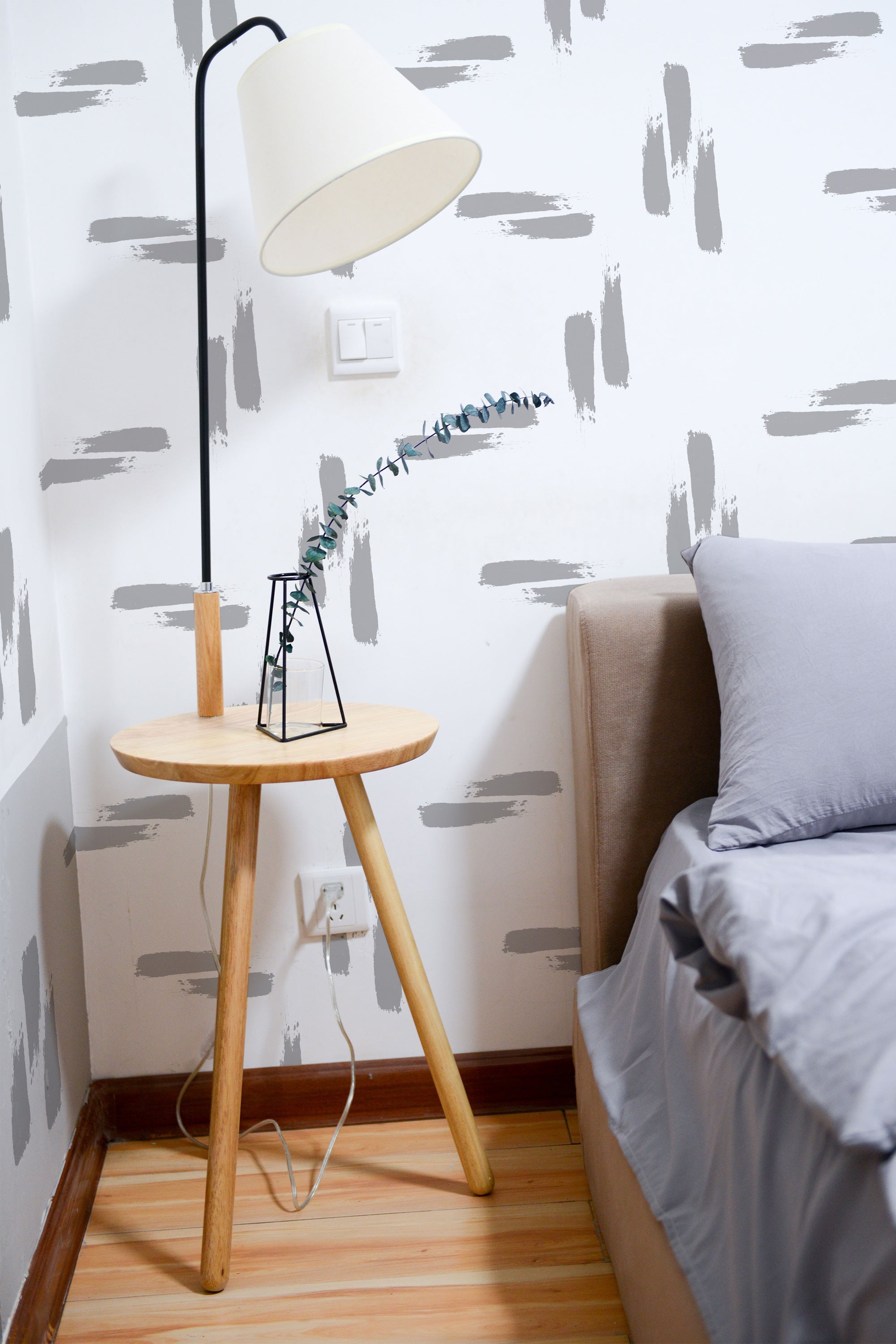 Self-adhesive wallpaper with gray brush stroke patterns on a white background, adding a modern and artistic touch to the room decor.