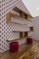 Wallpaper with intricate burgundy damask motifs set against a white background, creating a rich, ornate aesthetic. The wooden floating shelves and hardwood flooring complement the warm tones of the design, enhancing the vintage elegance of the room. Traditional wallpaper.