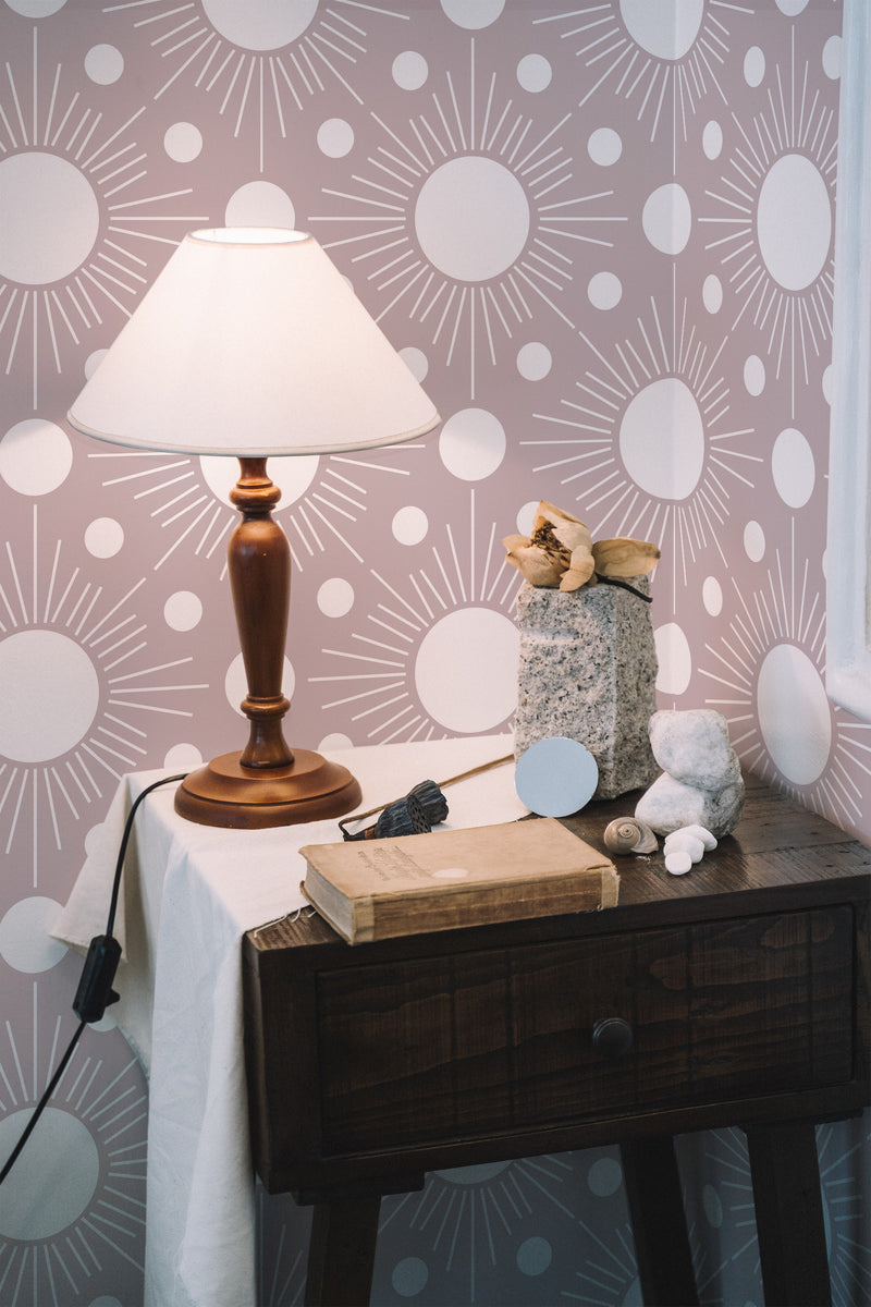 Self-adhesive wallpaper with a Boho sun design, featuring white suns with simple rays on a muted mauve background.