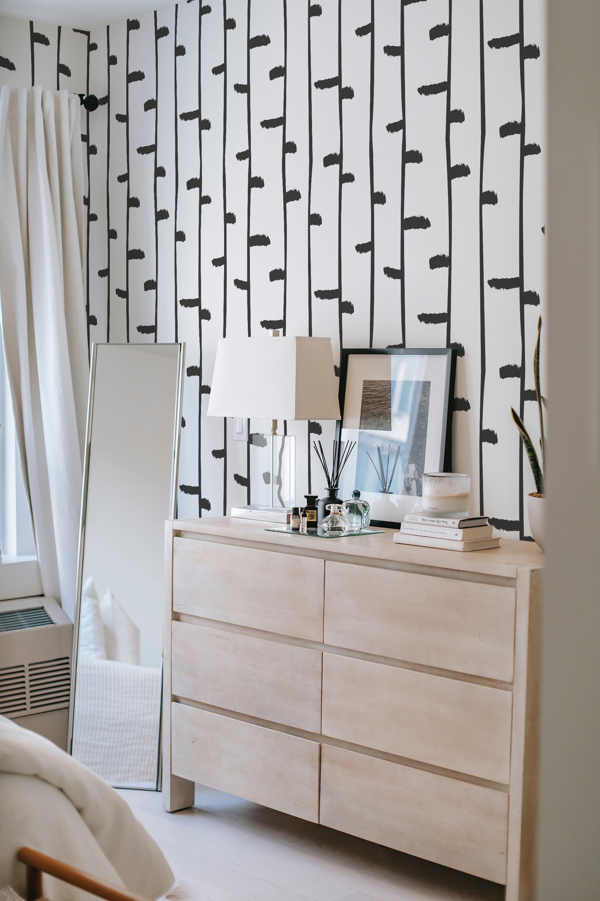 The wallpaper on the wall is a minimalist design with black birch trees set against a white background, creating a clean, natural look. Traditional wallpaper.