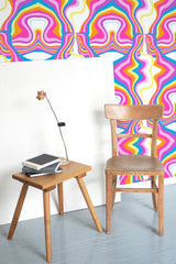 Self-adhesive wallpaper with a Funky psychedelic design in vibrant hues of pink, yellow, orange, blue, and white, creating a wavy, abstract pattern.