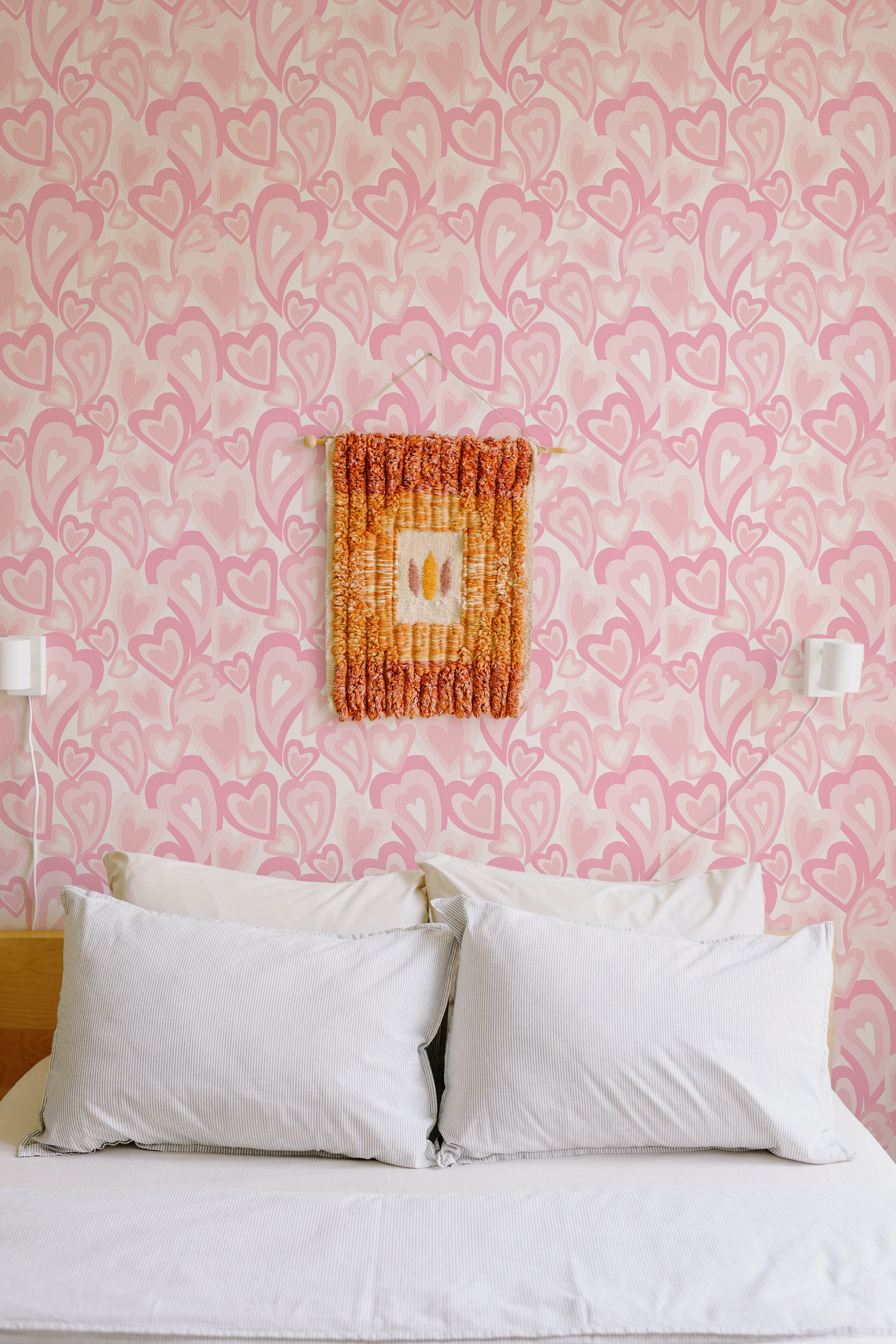 Self-adhesive wallpaper with a repeating heart pattern in various shades of pink, creating a playful and romantic ambiance in the room.