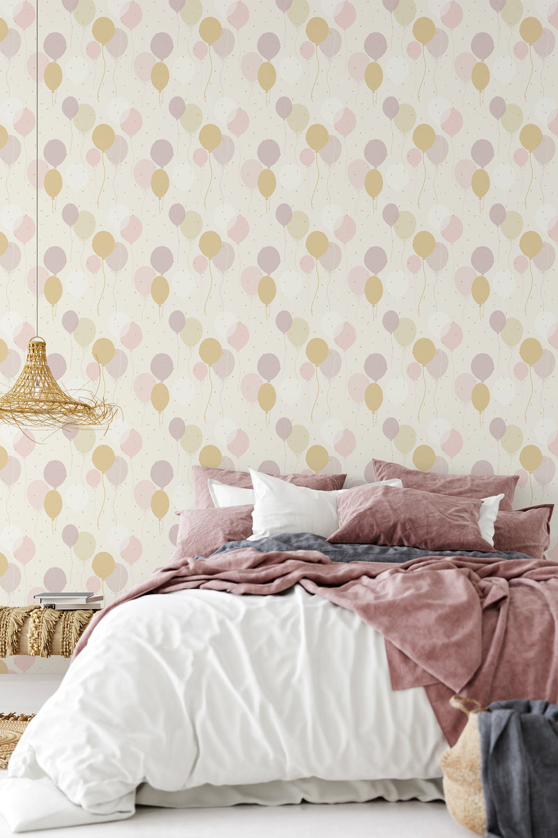 Wallpaper design with whimsical balloons in soft pastel shades of pink, beige, and cream, patterned diagonally across a light, cream-colored background. Traditional wallpaper.