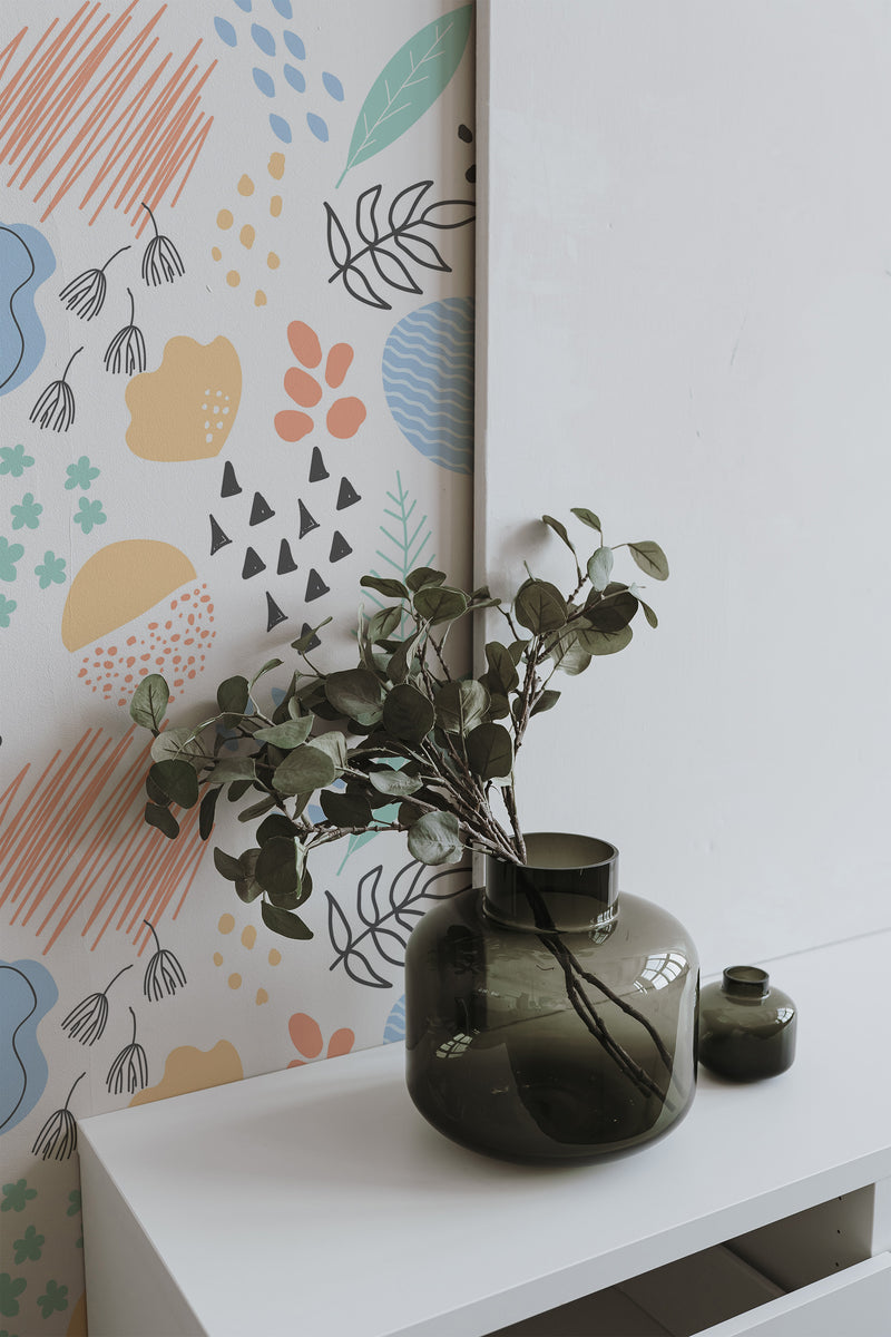 Self-adhesive Bohemian wallpaper with eclectic patterns including hand-drawn shapes, abstract leaves, and pastel colors like salmon, teal, and mustard, creating a vibrant and artistic atmosphere in the room.