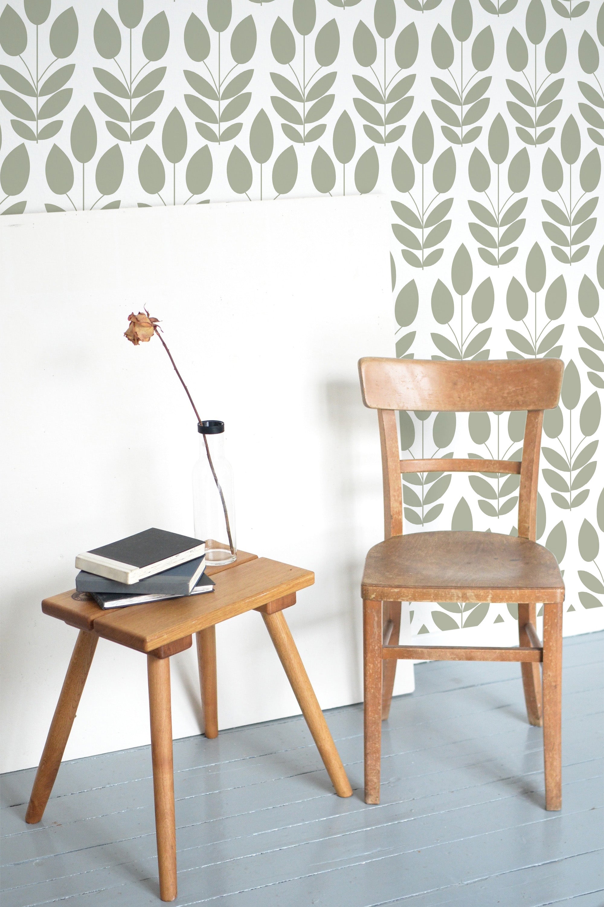Self-adhesive Scandinavian wallpaper with a minimalist leaf pattern in a soft green hue on a white background, offering a clean and modern aesthetic to the room.