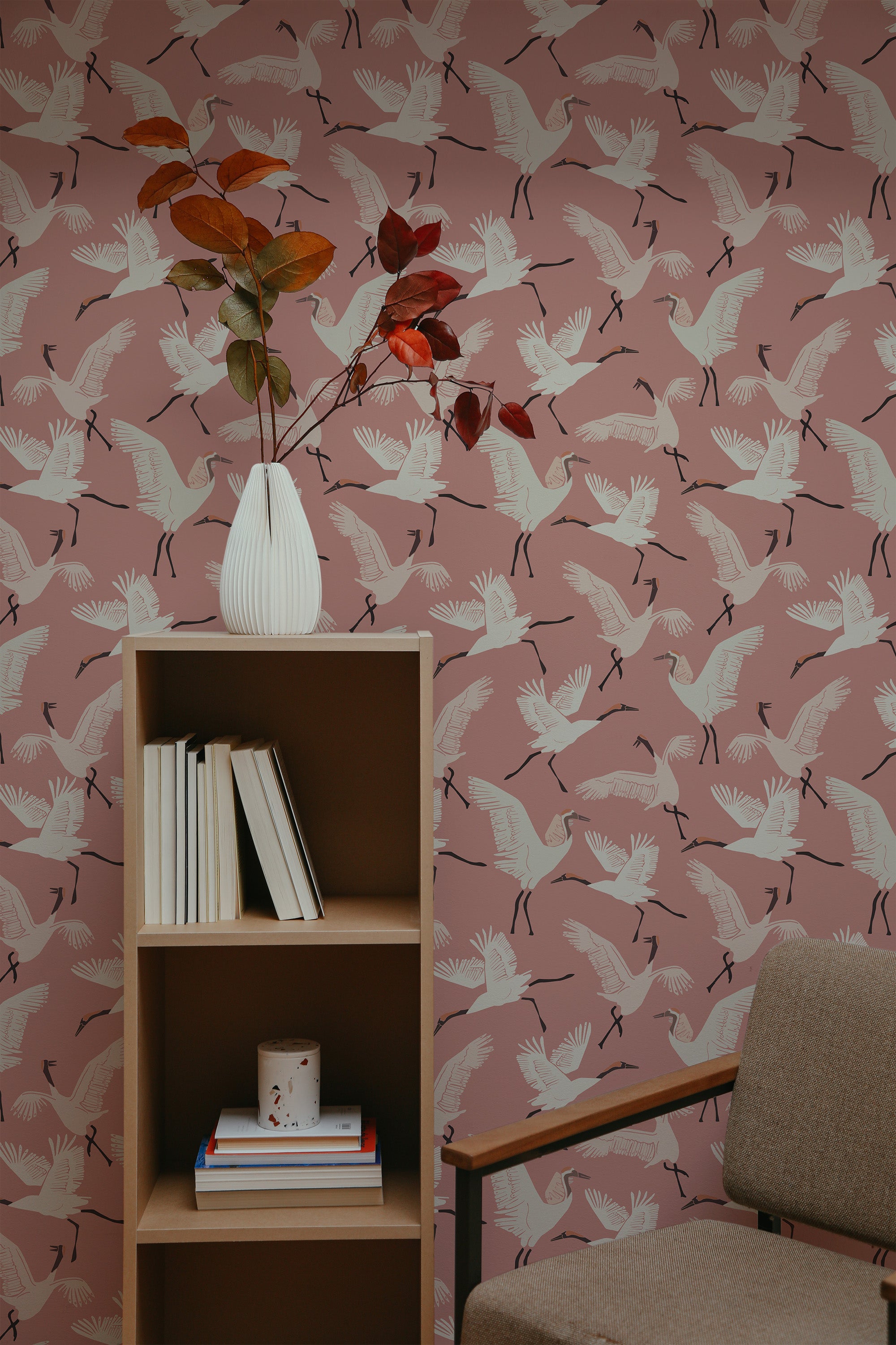 Self-adhesive wallpaper with a design of white cranes in flight on a soft pink background, paired with scattered leaves.