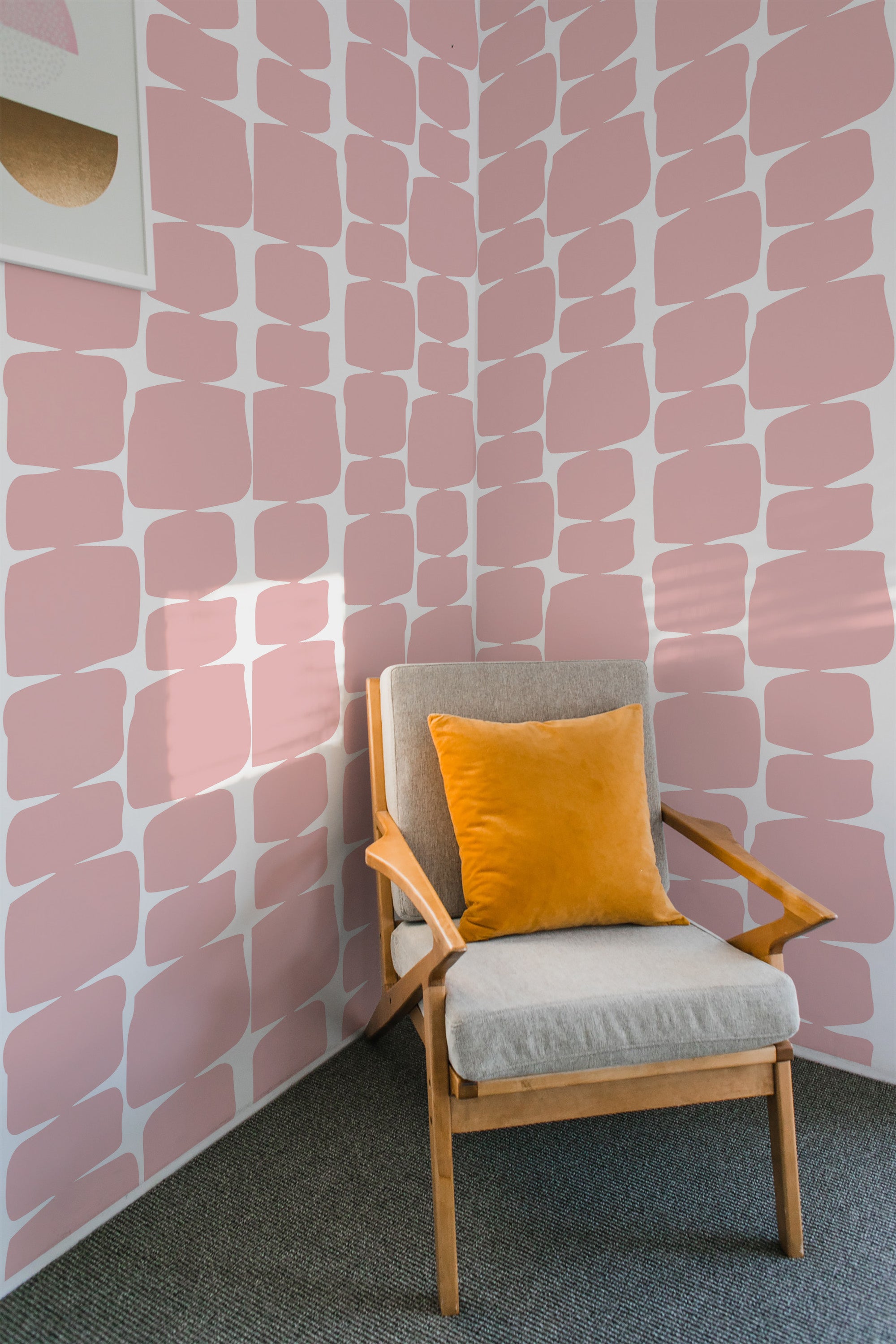 A room with wallpaper decorated in a pink retro shape pattern, featuring soft, overlapping rectangles on a white background, creating a modern yet timeless aesthetic in traditional wallpaper.