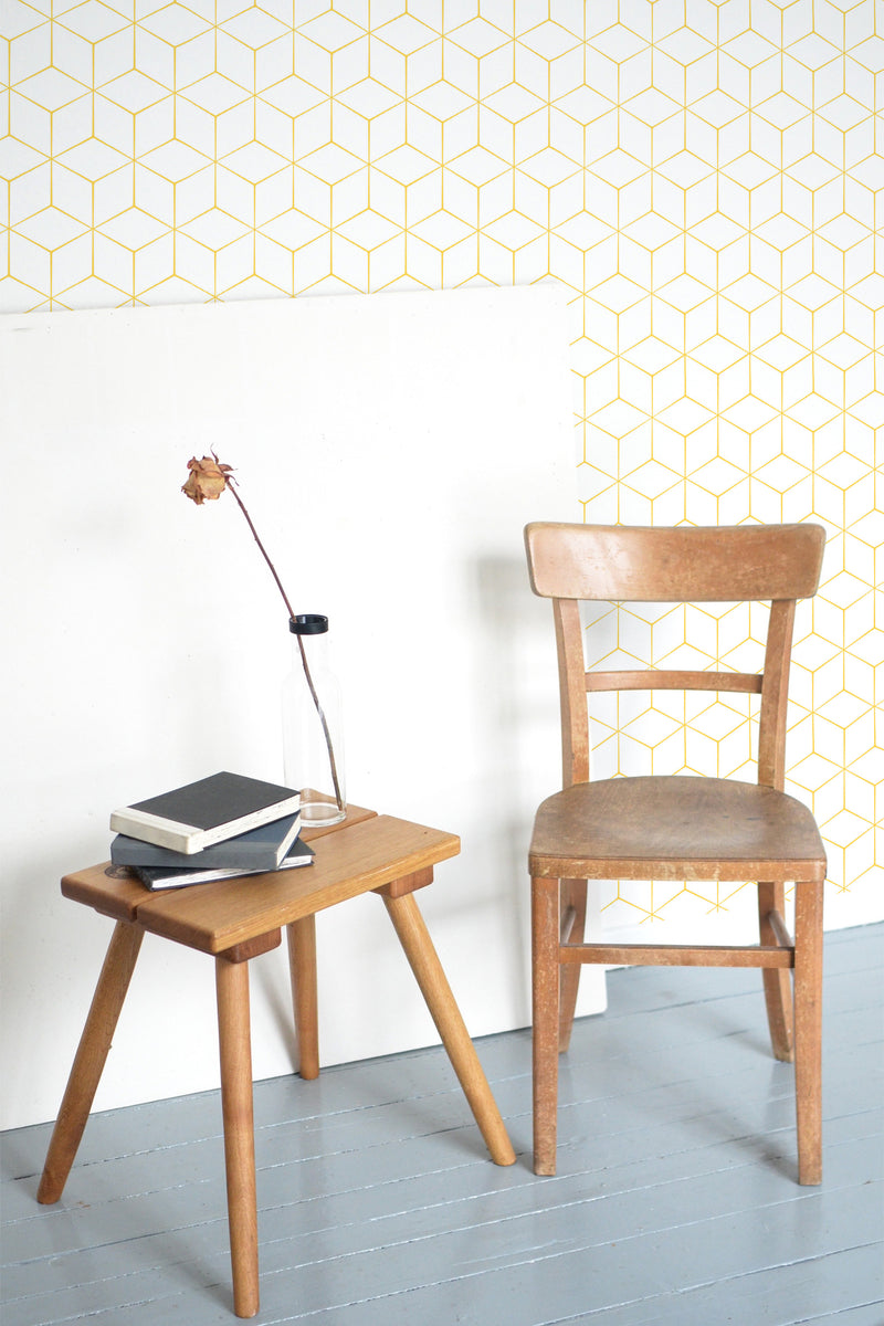 Self-adhesive wallpaper with a geometric pattern of yellow lines forming interconnected cubes on a light background.