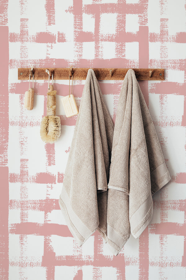 Self-adhesive wallpaper with a Brush Grid design in soft pink, featuring a pattern of irregular, hand-drawn lines forming a loose grid on a white background.