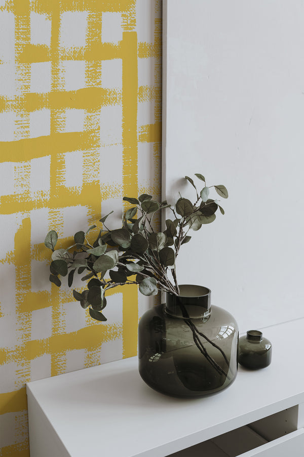 Self-adhesive wallpaper with a yellow brush grid design created on a white background.