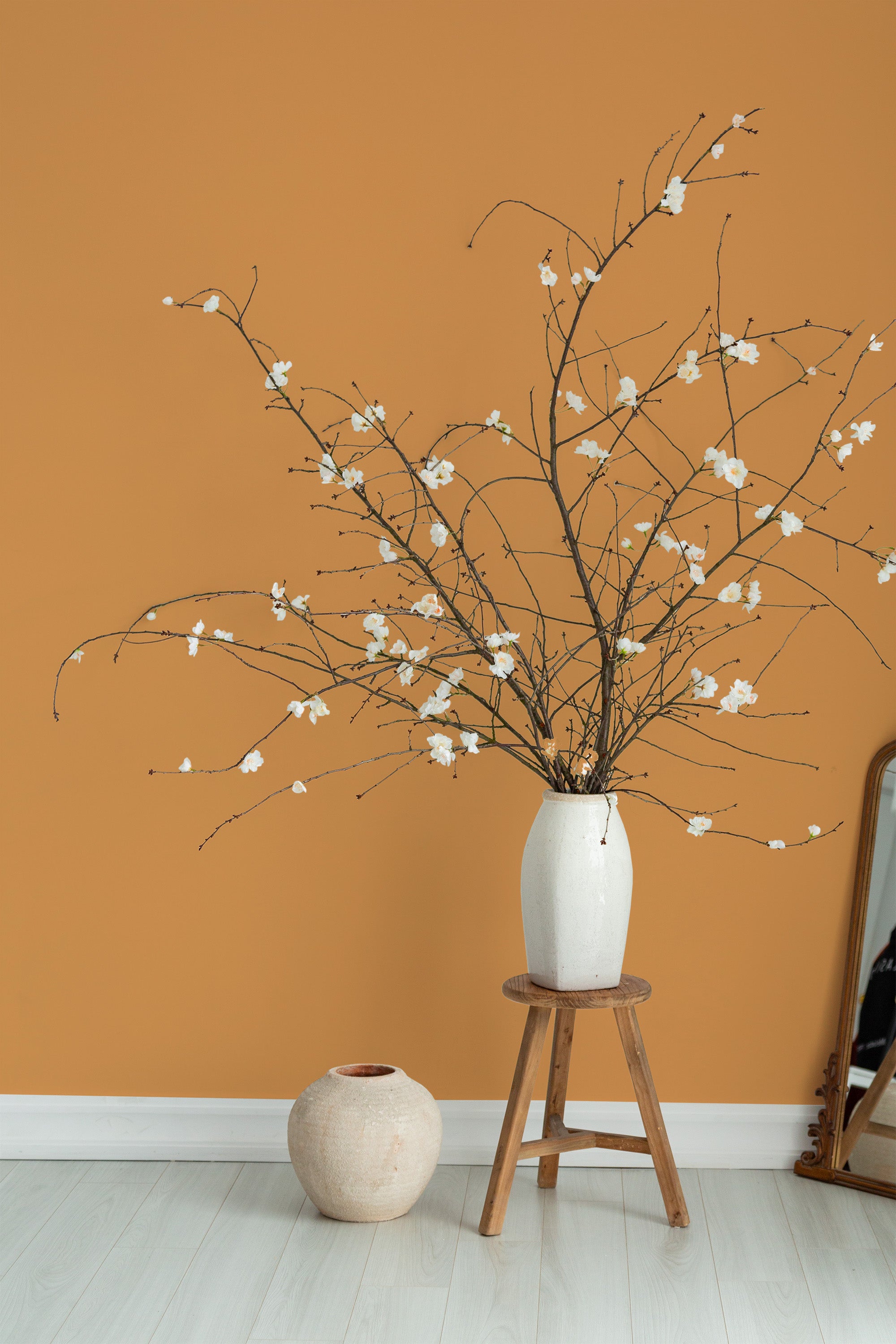 Self-adhesive wallpaper in a solid warm orange hue, creating a modern, minimalist backdrop.
