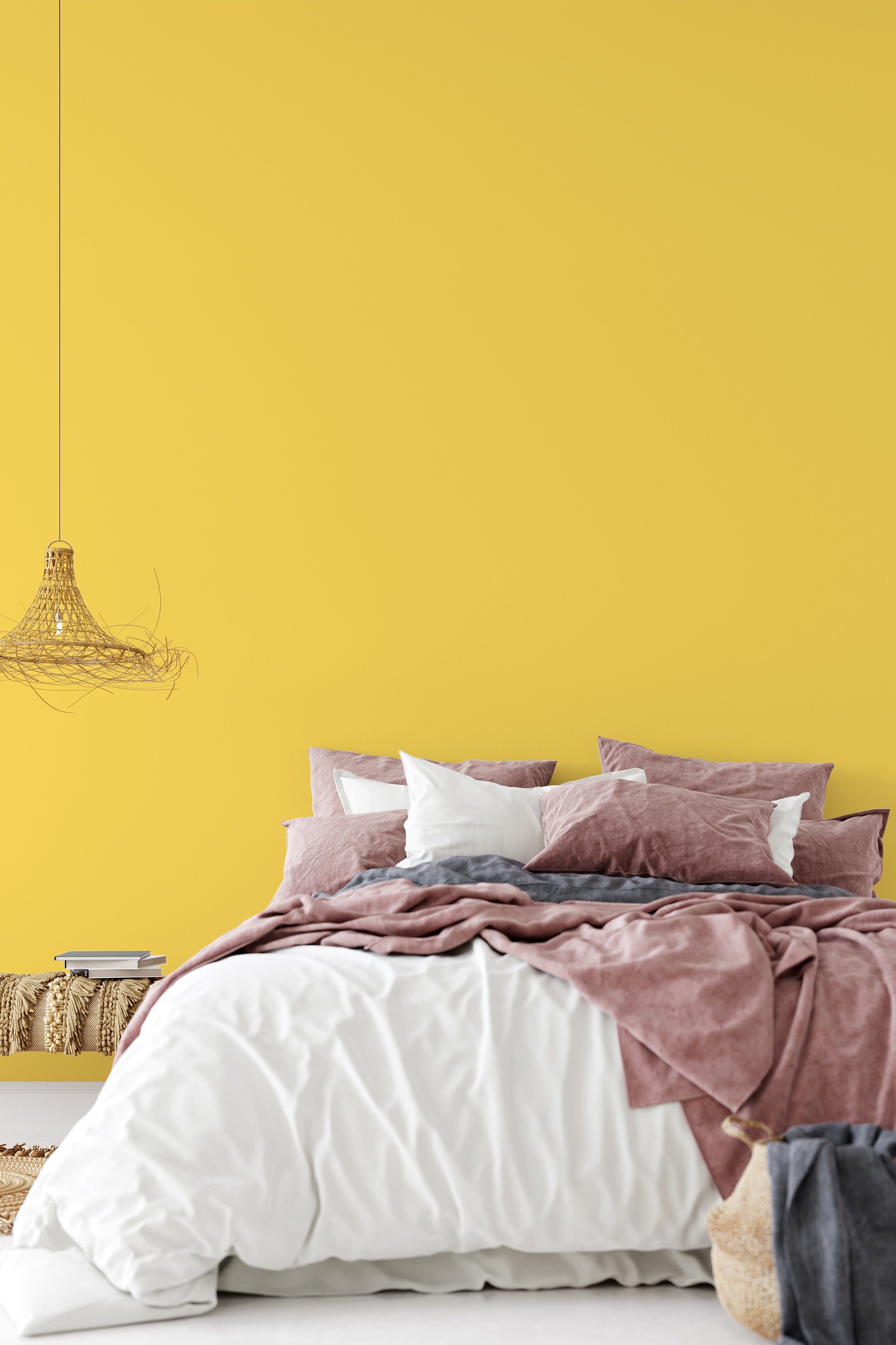 A room with a soft yellow colored plain wallpaper behind a bed adorned with white, pink, and gray bedding, creating a cozy and warm atmosphere,raditional wallpaper.