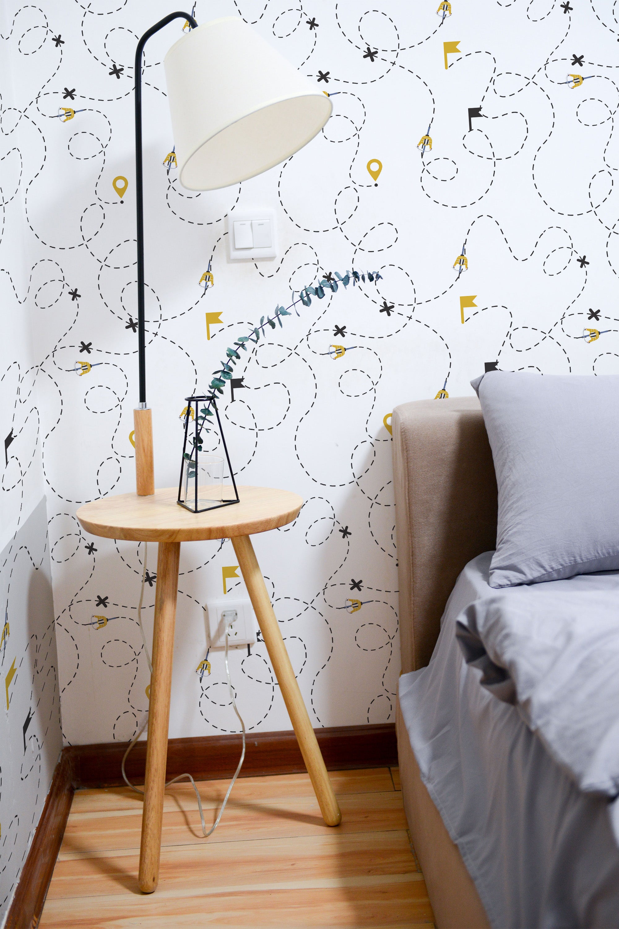 Self-adhesive wallpaper with a playful Tour de France design of bicycles, directional arrows, and intricate winding paths in black and yellow on a white background.