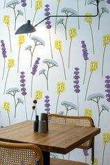 Self-adhesive wallpaper with a Lavender Meadow design of scattered lavender, yellow, and light blue flowers against a white background, adding a fresh and natural touch to the room.