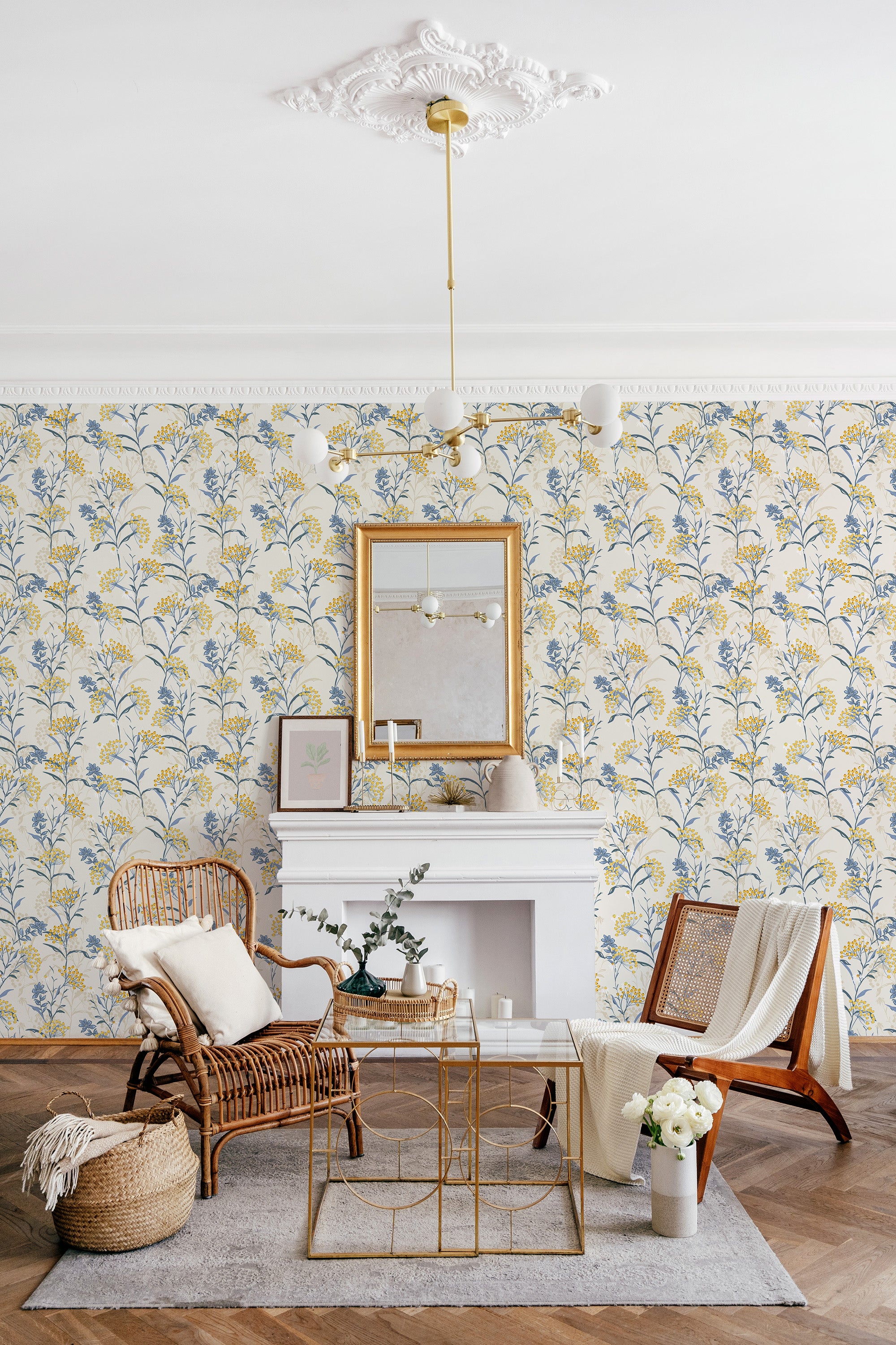 Vintage floral wallpaper with an intricate pattern of soft yellow and blue flowers on delicate branching stems, interspersed with subtle green leaves, against a cream background, creating a charming and classic ambiance for the space. Traditional wallpaper.