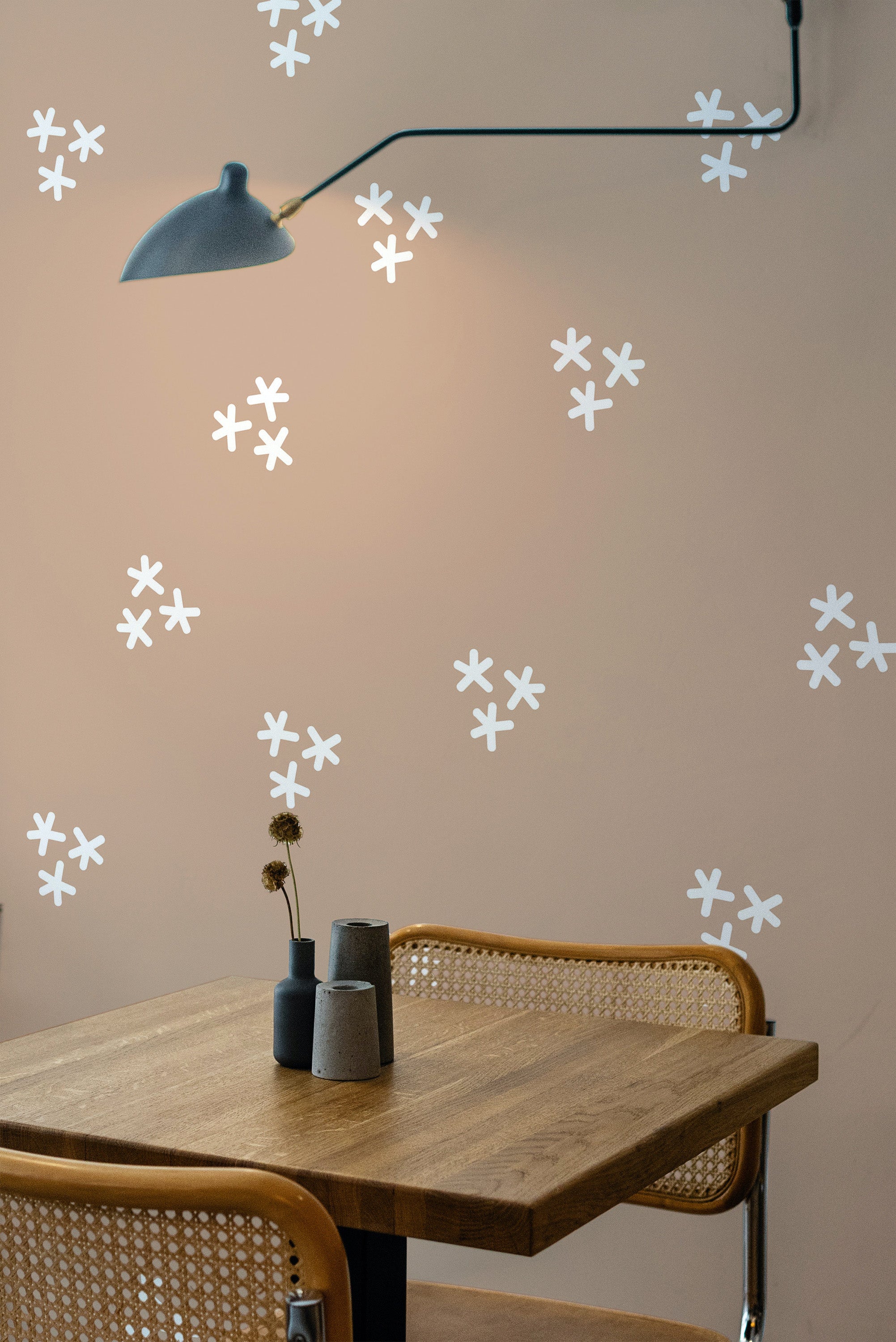 Self-adhesive wallpaper with a Nursery floral design featuring small white, petal-like flowers scattered across a soft beige background.