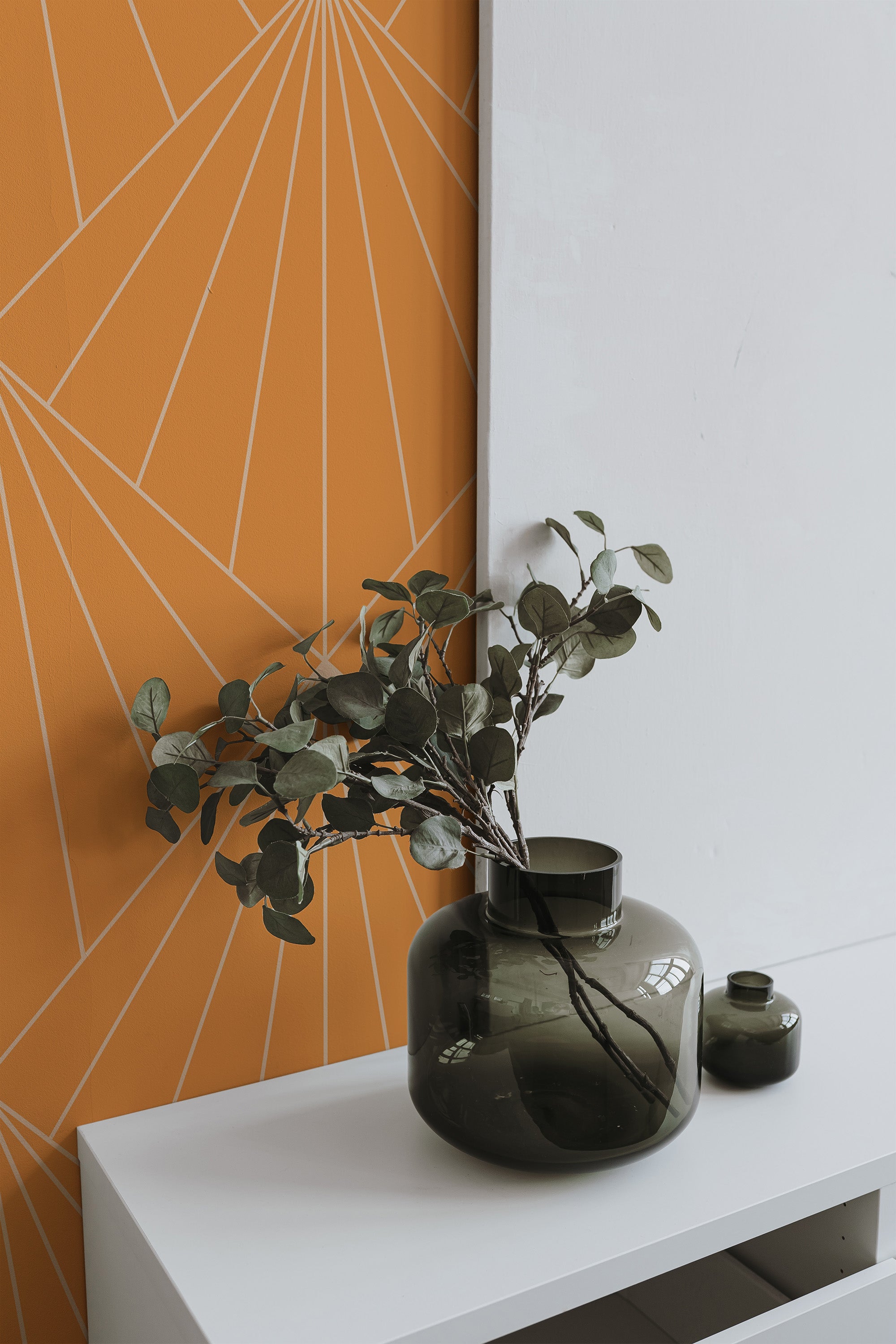 Self-adhesive wallpaper with geometric sun rays pattern on an orange background, creating a modern and vibrant design. The sun rays are minimalist lines that spread outward, giving a dynamic and radiant look to the room.