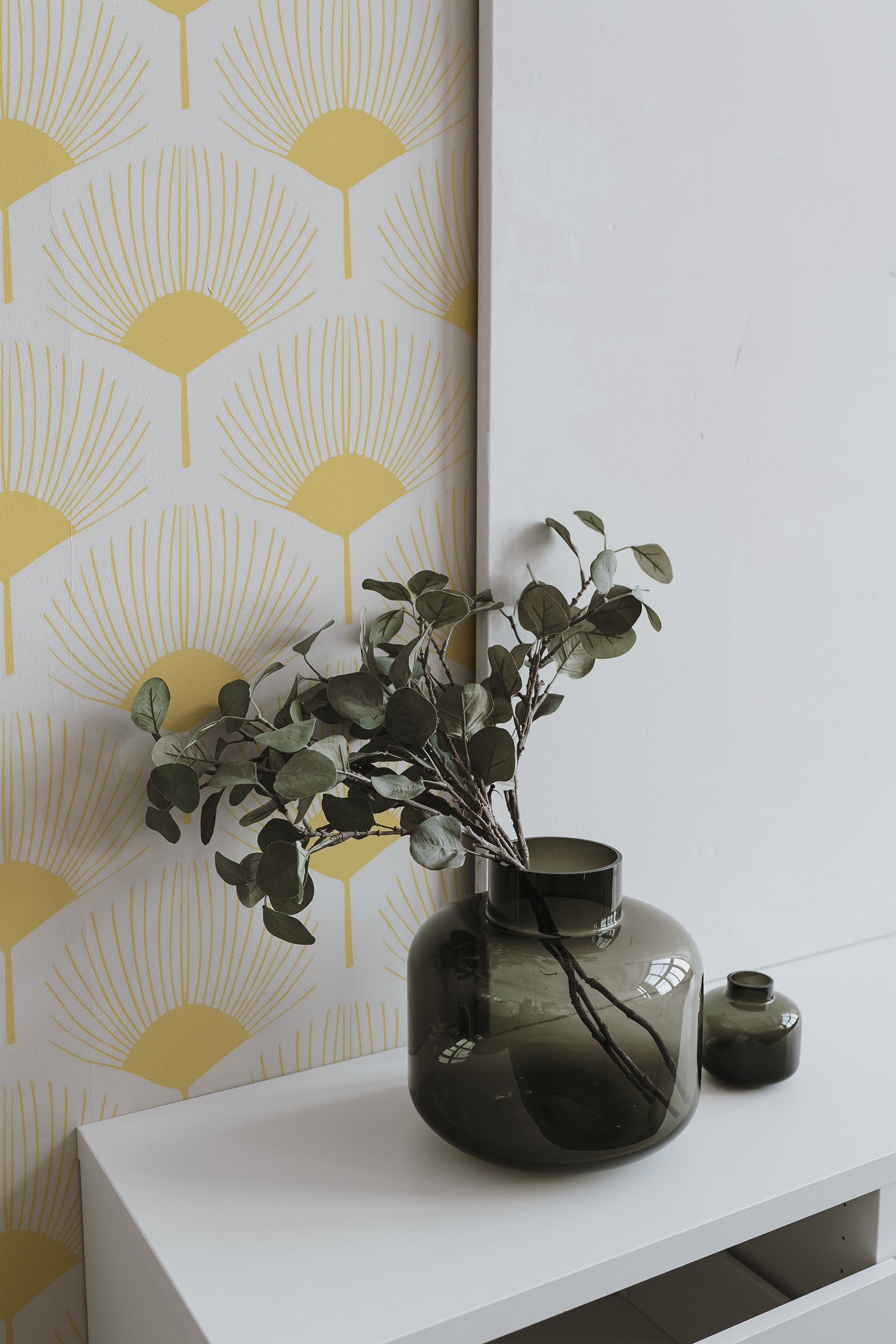 Self-adhesive wallpaper with an abstract botanical pattern featuring stylized golden-yellow fan-shaped leaves on a muted cream background.