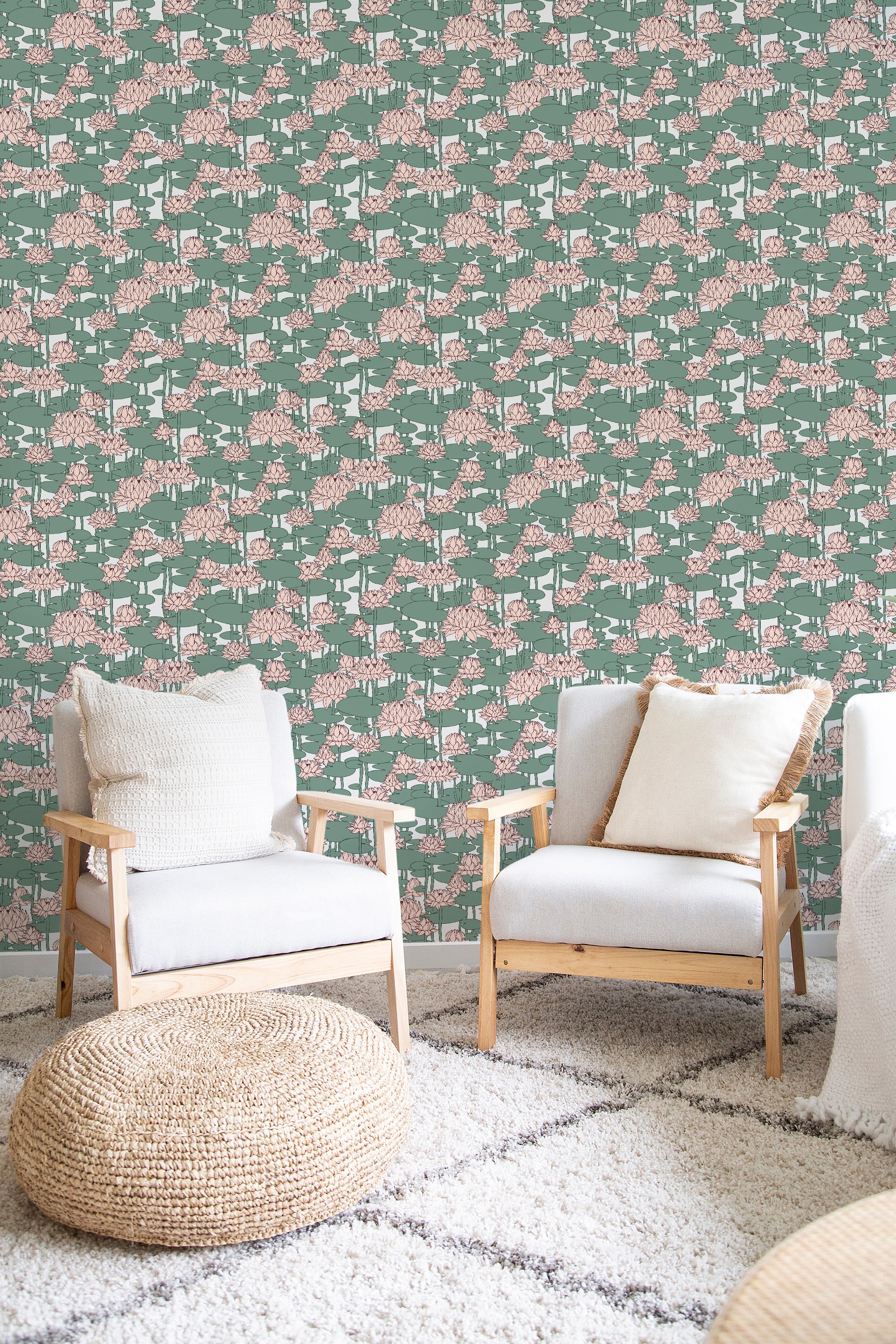 A room with wallpaper on the wall adorned with a Lotus flower pattern in soft pinks and greens. The design has a delicate, repeating motif in an intricate style. The chairs and woven floor cushion add to the cozy ambiance, complementing the refined, traditional wallpaper.