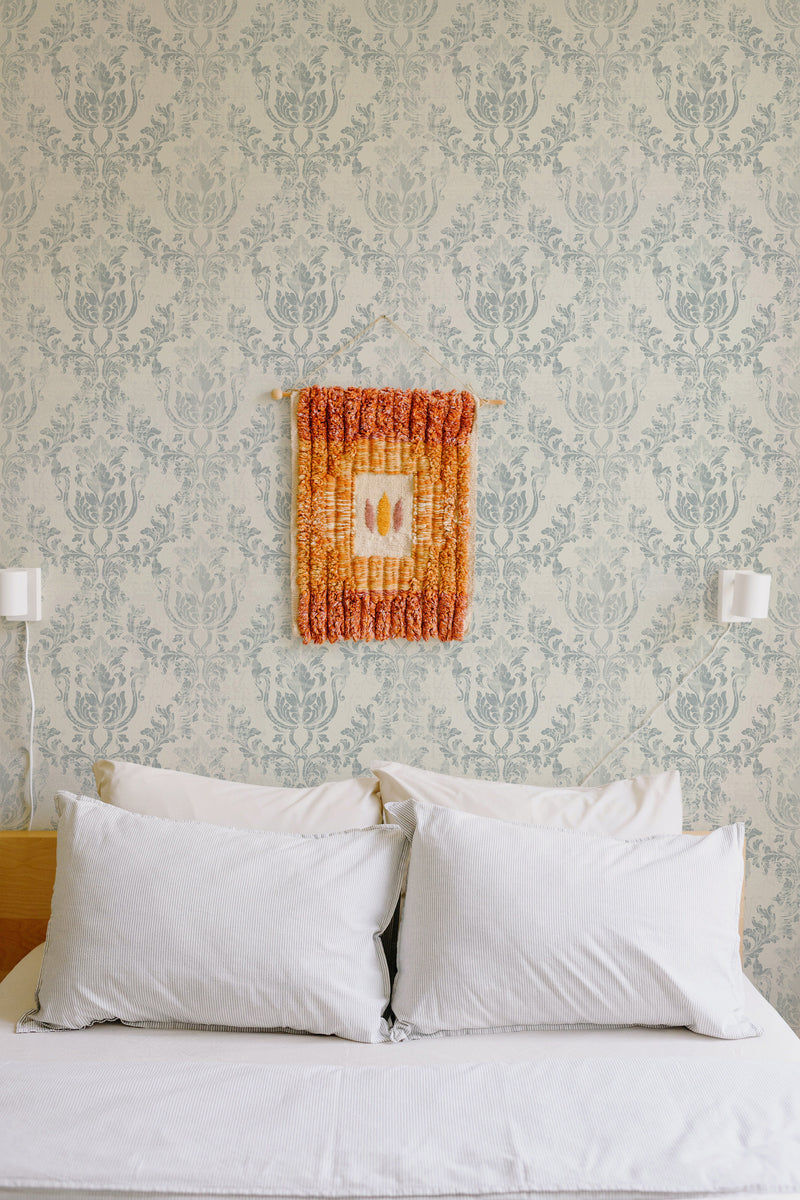 Self-adhesive wallpaper with an old-school damask pattern in light gray on a cream-colored background, offering a vintage and classic aesthetic to the room.