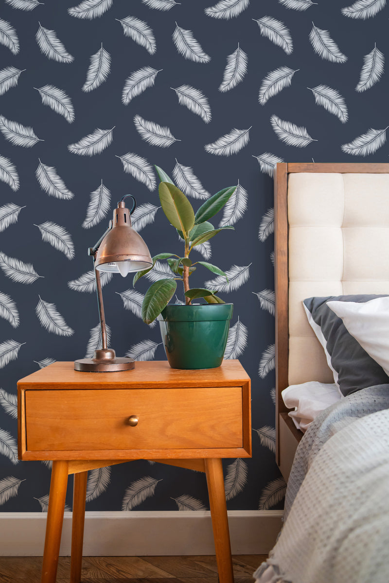 Self-adhesive Tossed Palm wallpaper with white palm leaves scattered on a dark blue background, adding a tropical and modern touch to the room.