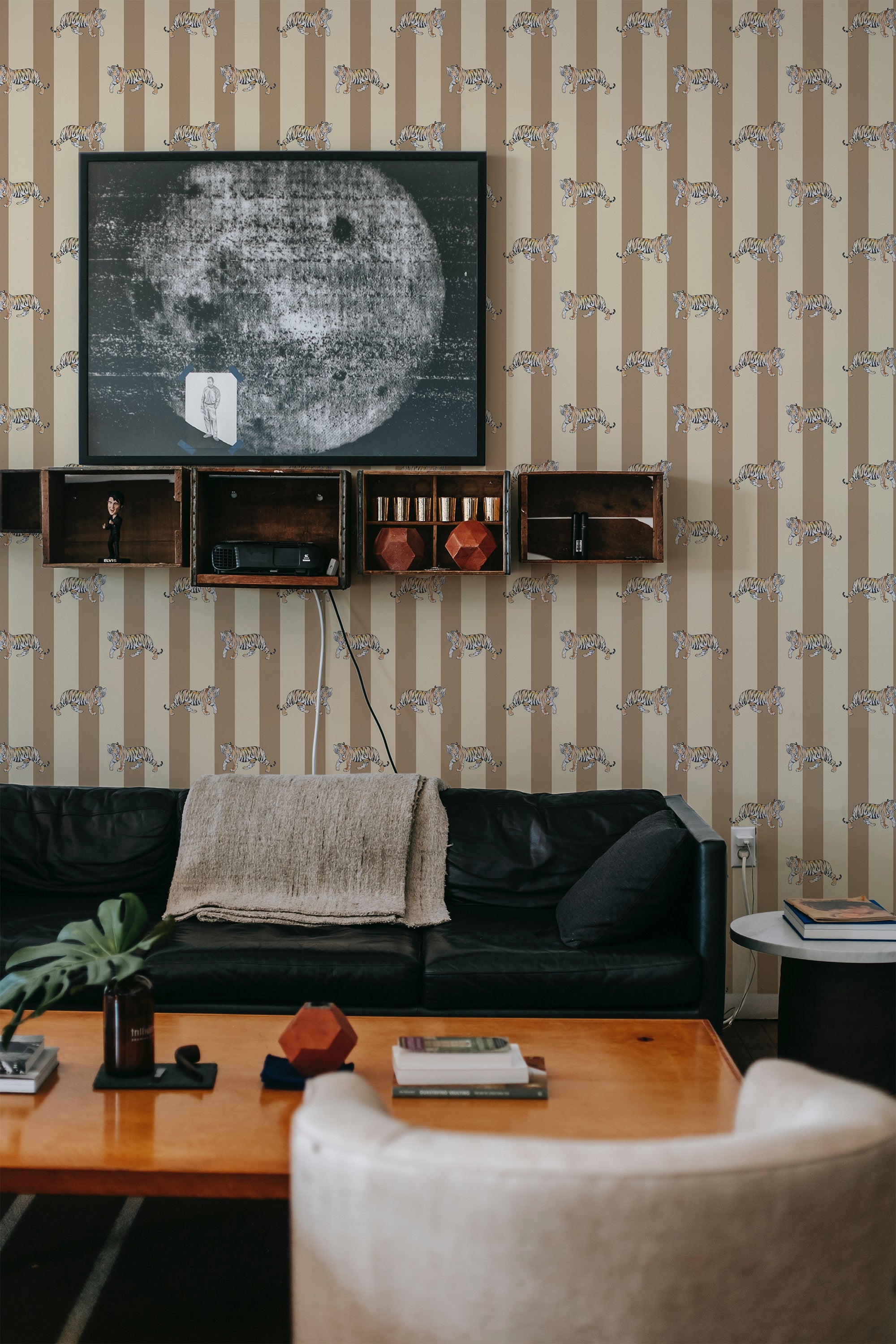 Beige wallpaper adorned with delicate tiger motifs spaced evenly across vertical brown stripes in a living room. Traditional wallpaper.