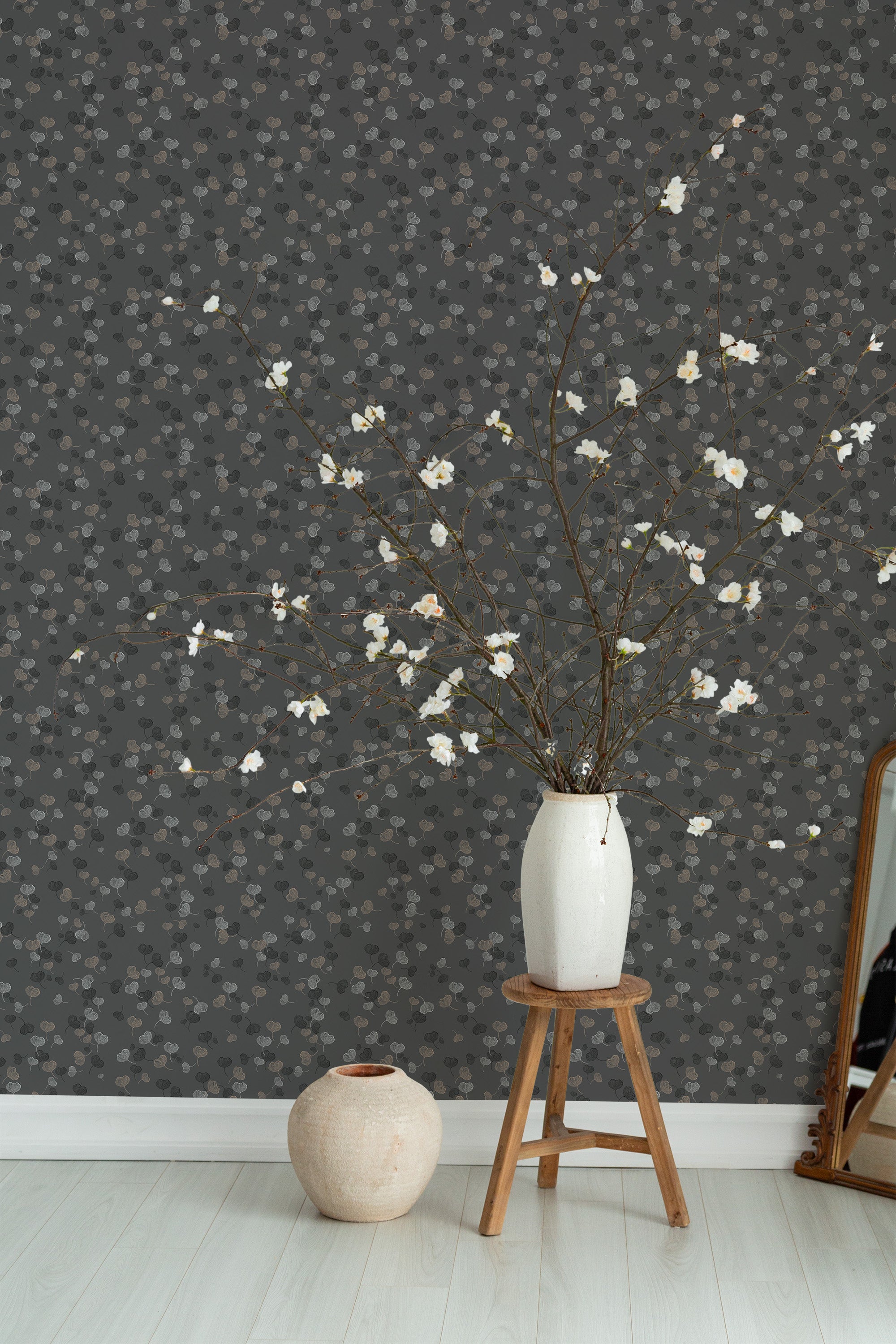 Self-adhesive wallpaper with a Ginko design in shades of gray and muted tones, featuring delicate fan-shaped leaves that create a subtle, elegant pattern against a dark background.