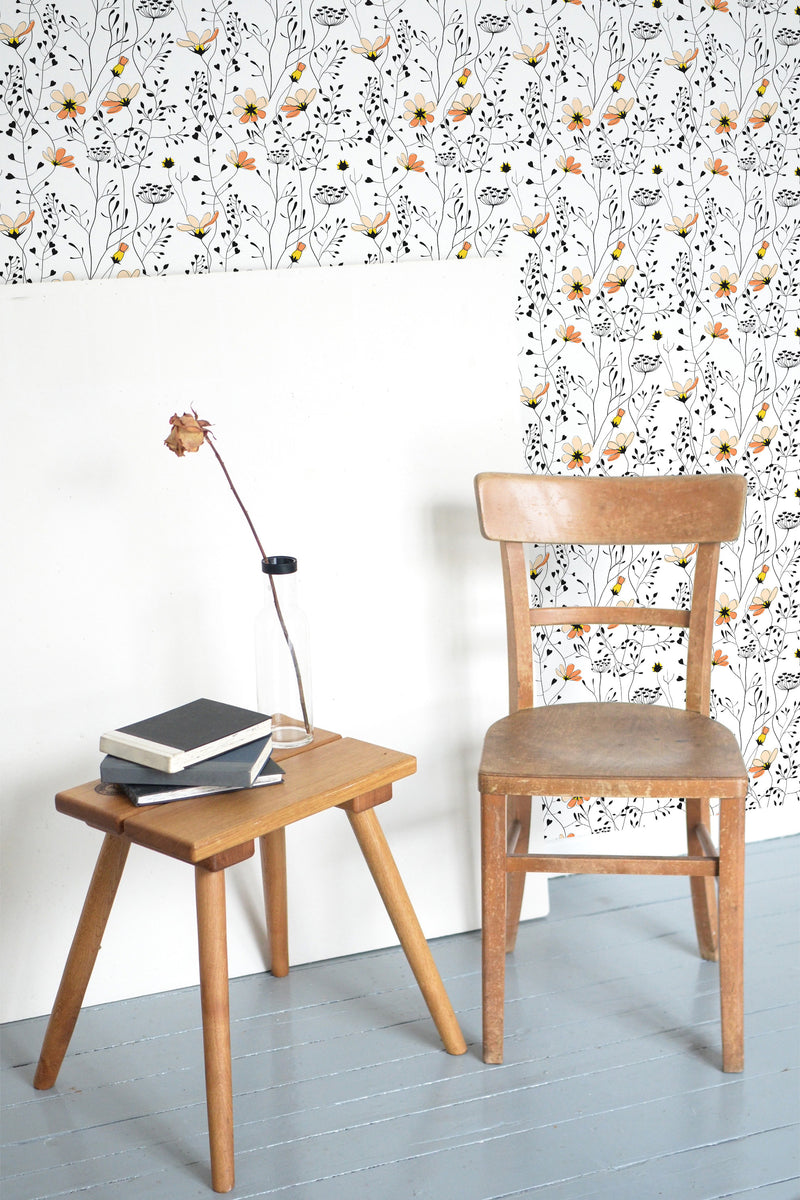 Self-adhesive floral wallpaper with delicate black and white botanical elements interspersed with vibrant orange and yellow flowers set on a white background.