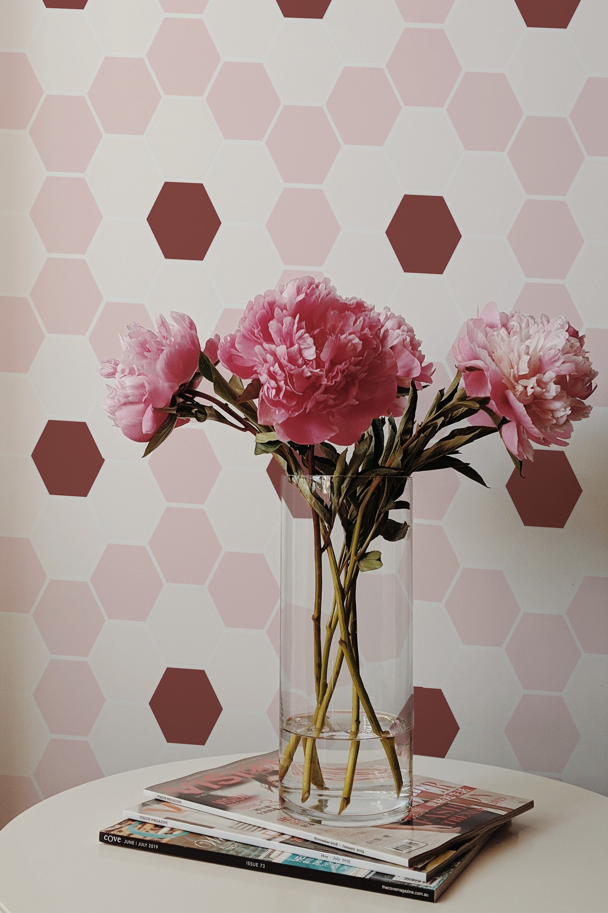 Self-adhesive wallpaper with a geometric floral tile design in a honeycomb pattern of pink and brown hexagons, enhancing the wall with modern, elegant shapes.