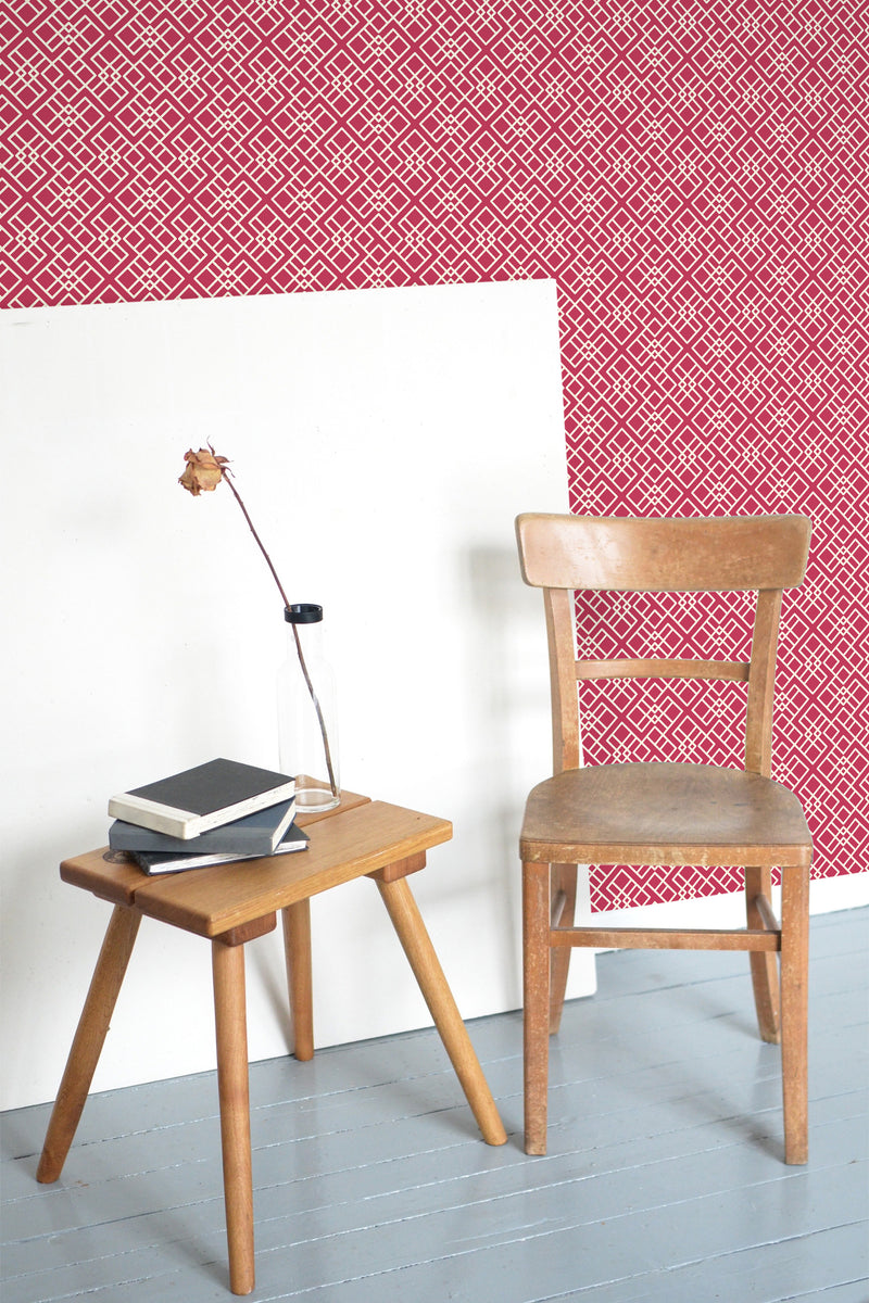 Self-adhesive wallpaper with a Viva Magenta ethnic pattern of geometric shapes in a repeating, intricate design.