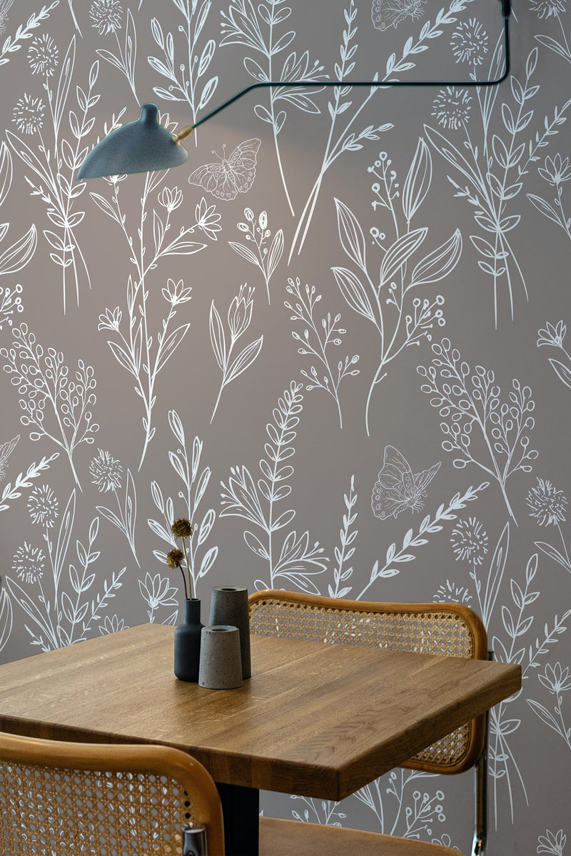 Self-adhesive Meadow line art wallpaper with delicate white floral and botanical illustrations on a soft grey background, complementing a modern, natural-themed interior.