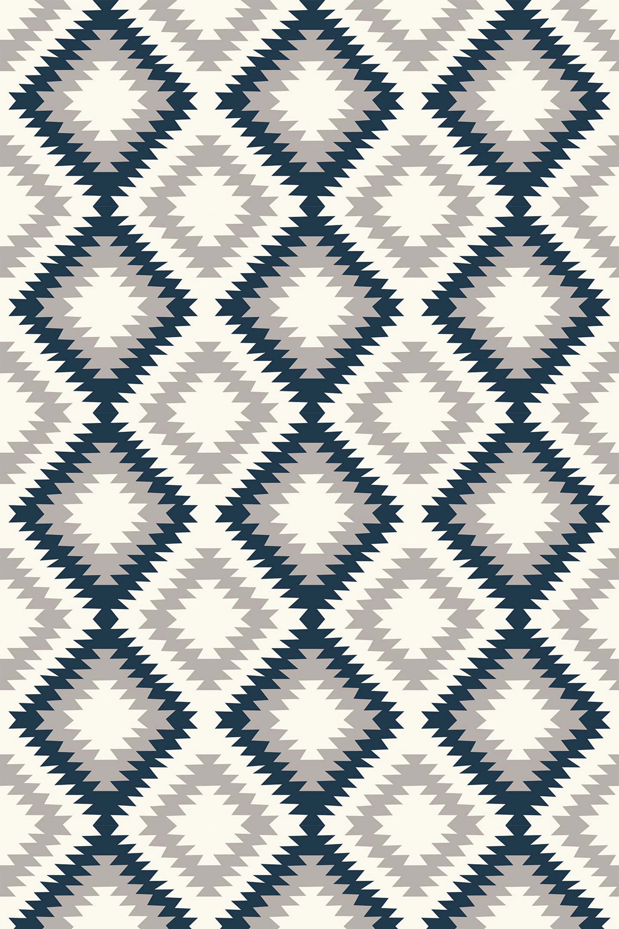 A repeating pattern of diamonds with sharp, zigzag edges, arranged in a grid. Each diamond alternates between shades of dark blue, gray, and cream, creating a striking, symmetrical geometric design inspired by Aztec motifs. Peel and stick removable wallpaper.