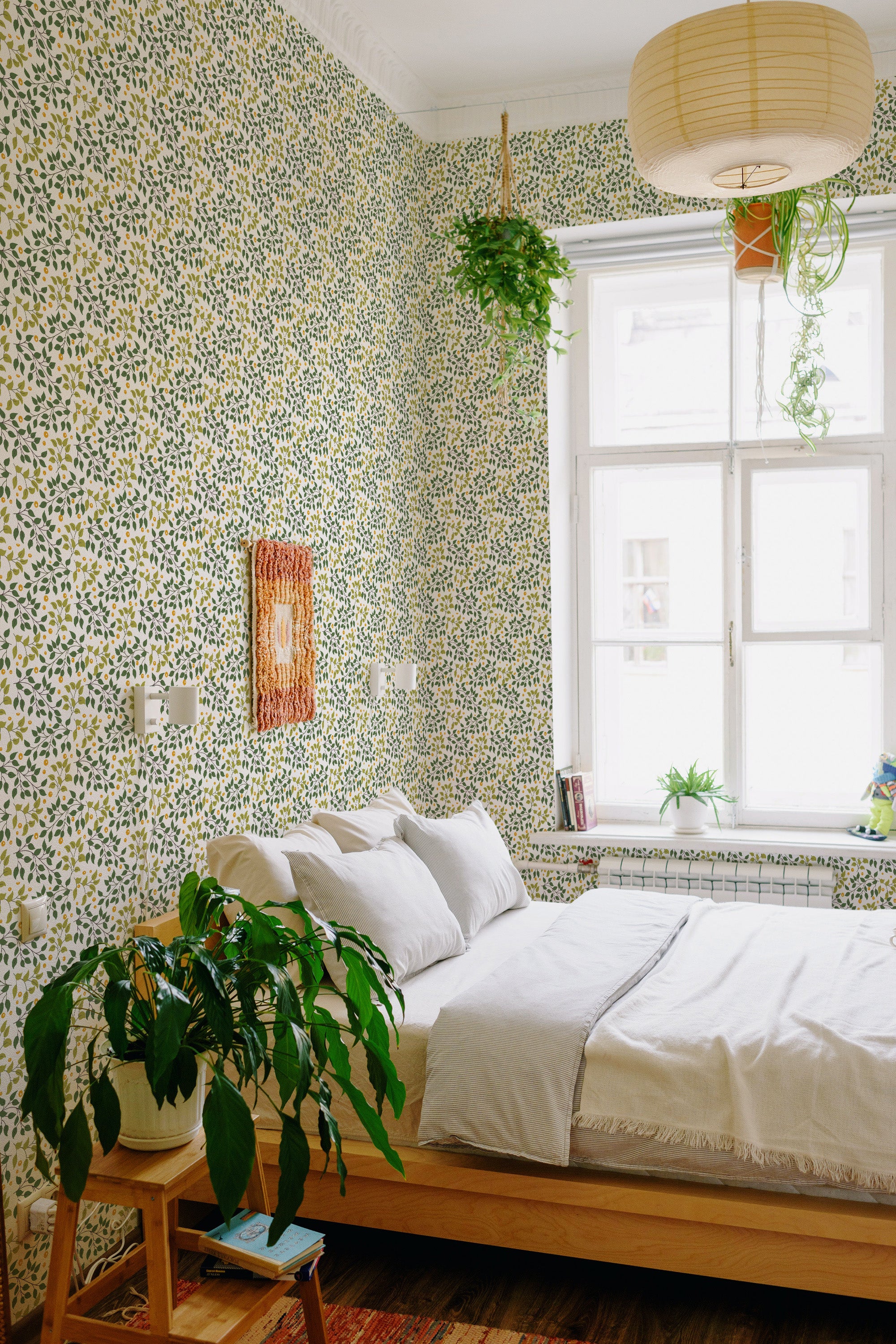 Green leaf dots wallpaper with a repetitive pattern of small green leaves scattered on a subdued light background, adding a fresh, botanical feel to the room. Traditional wallpaper.