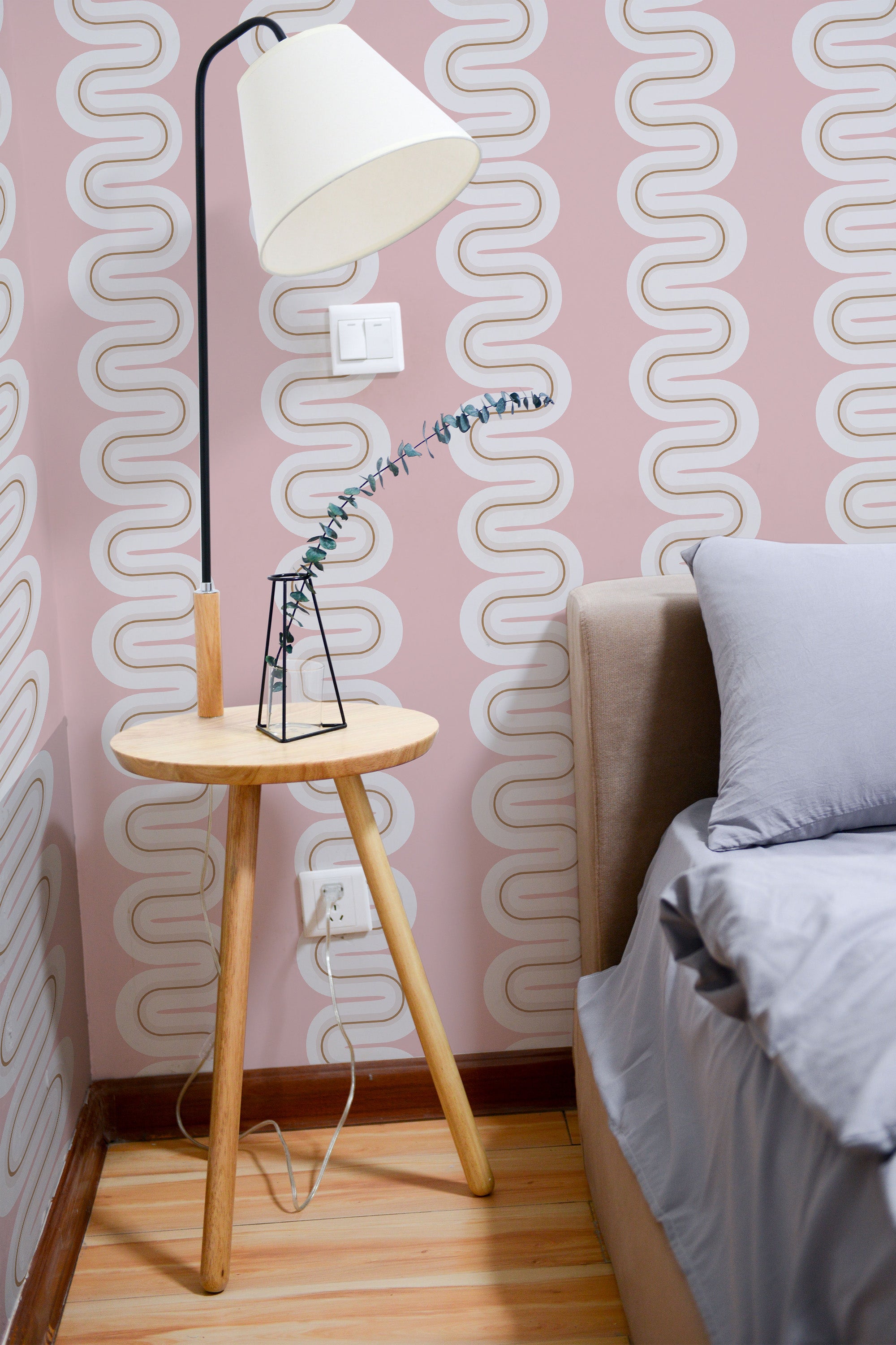 Self-adhesive Pink Eclectic Wave wallpaper with a retro-inspired, continuous curved pattern in white on a soft pink background, creating a stylish and modern ambiance in the room.