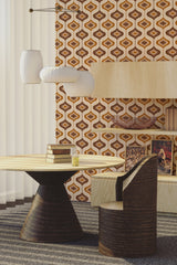 A room with 70s-style wallpaper in brown, orange, and beige geometric shapes. Traditional wallpaper.