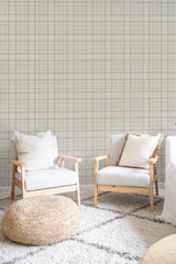 A wall adorned with neutral tartan-patterned wallpaper design has intersecting lines in shades of beige, cream, and soft grey tones, creating a cozy and classic feel for the room. Traditional wallpaper.