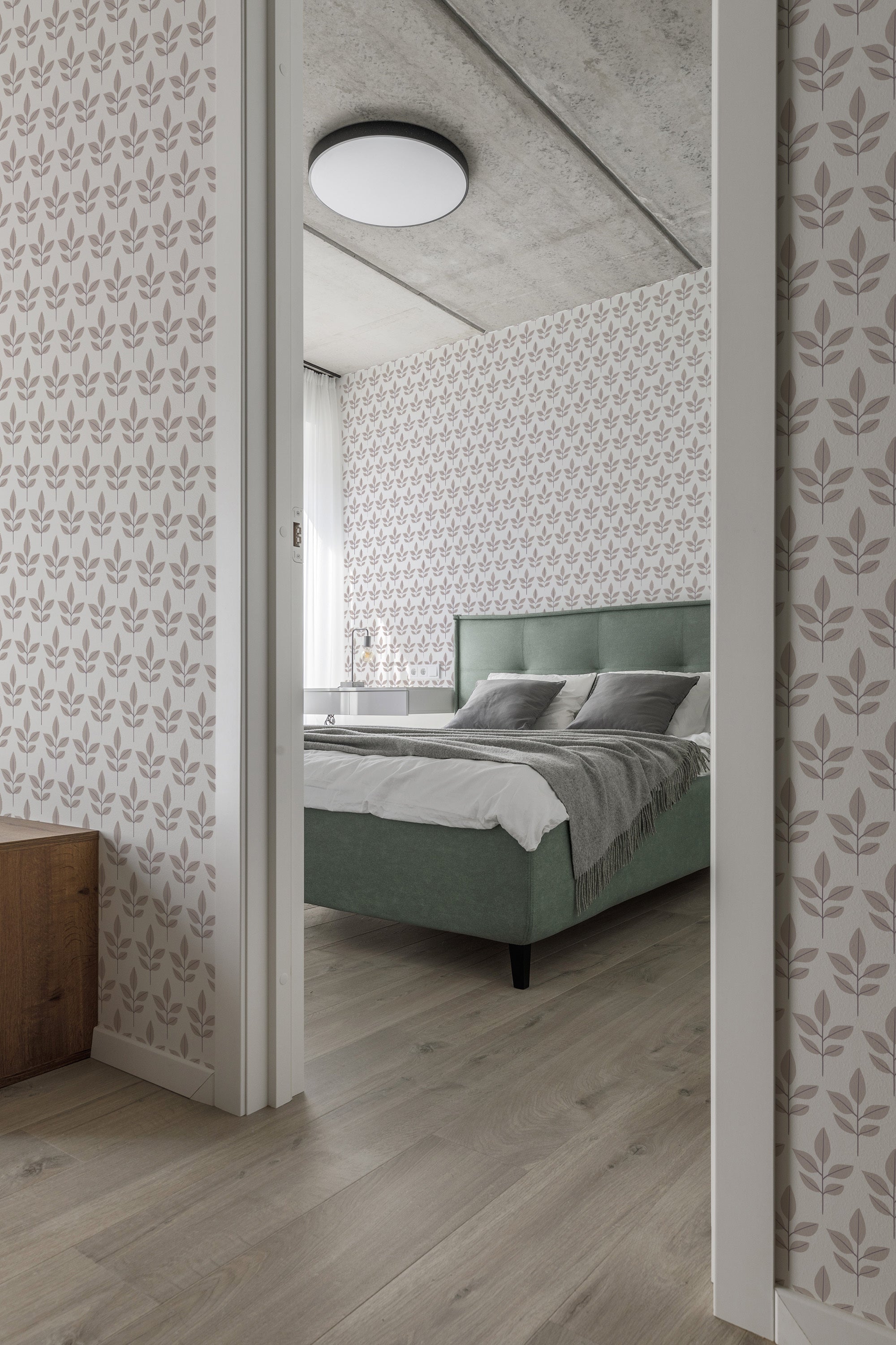 A room with light-colored walls adorned in a Scandi leaf pattern wallpaper, with repeating minimalist leaf motifs in soft, neutral tones, adding a subtle and calming aesthetic. The wallpaper complements the natural wooden floor and muted furnishings for a cohesive look, embodying traditional wallpaper.