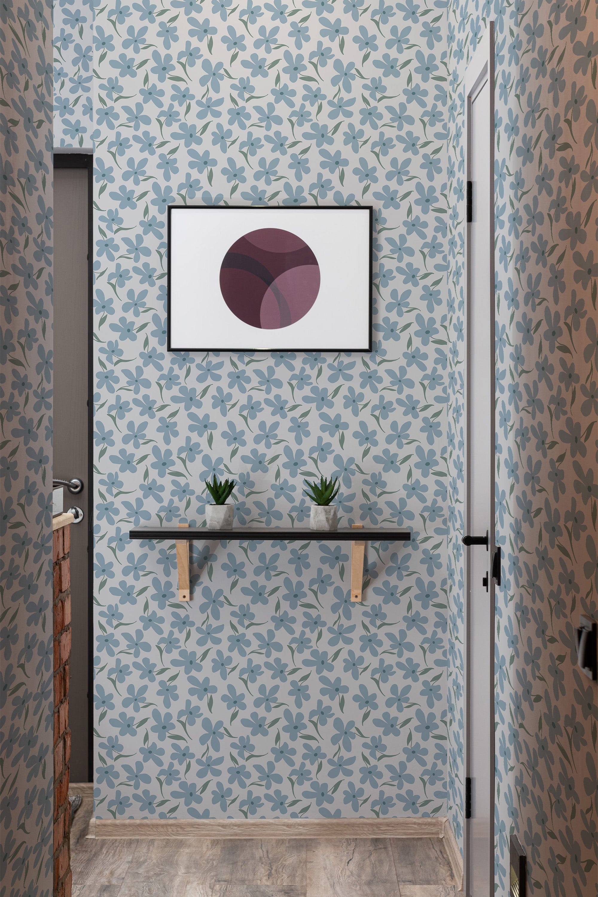 Light blue wallpaper with darker blue and teal floral patterns covering the walls in a hallway. A small shelf with two succulents sits below a modern art print. Traditional wallpaper.
