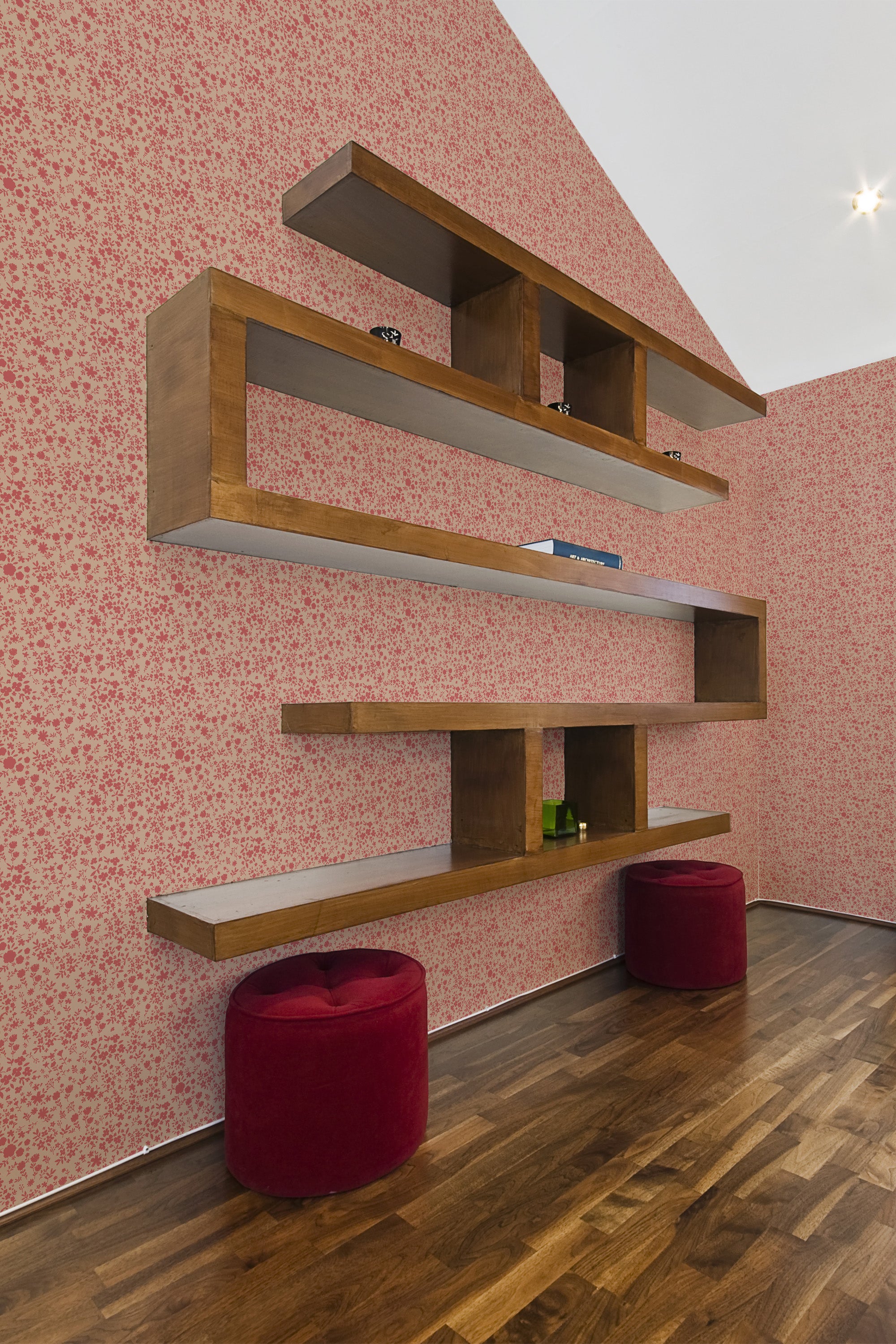 Small, delicate floral patterns cover the wall with a mix of soft pink and red tones on a traditional wallpaper.