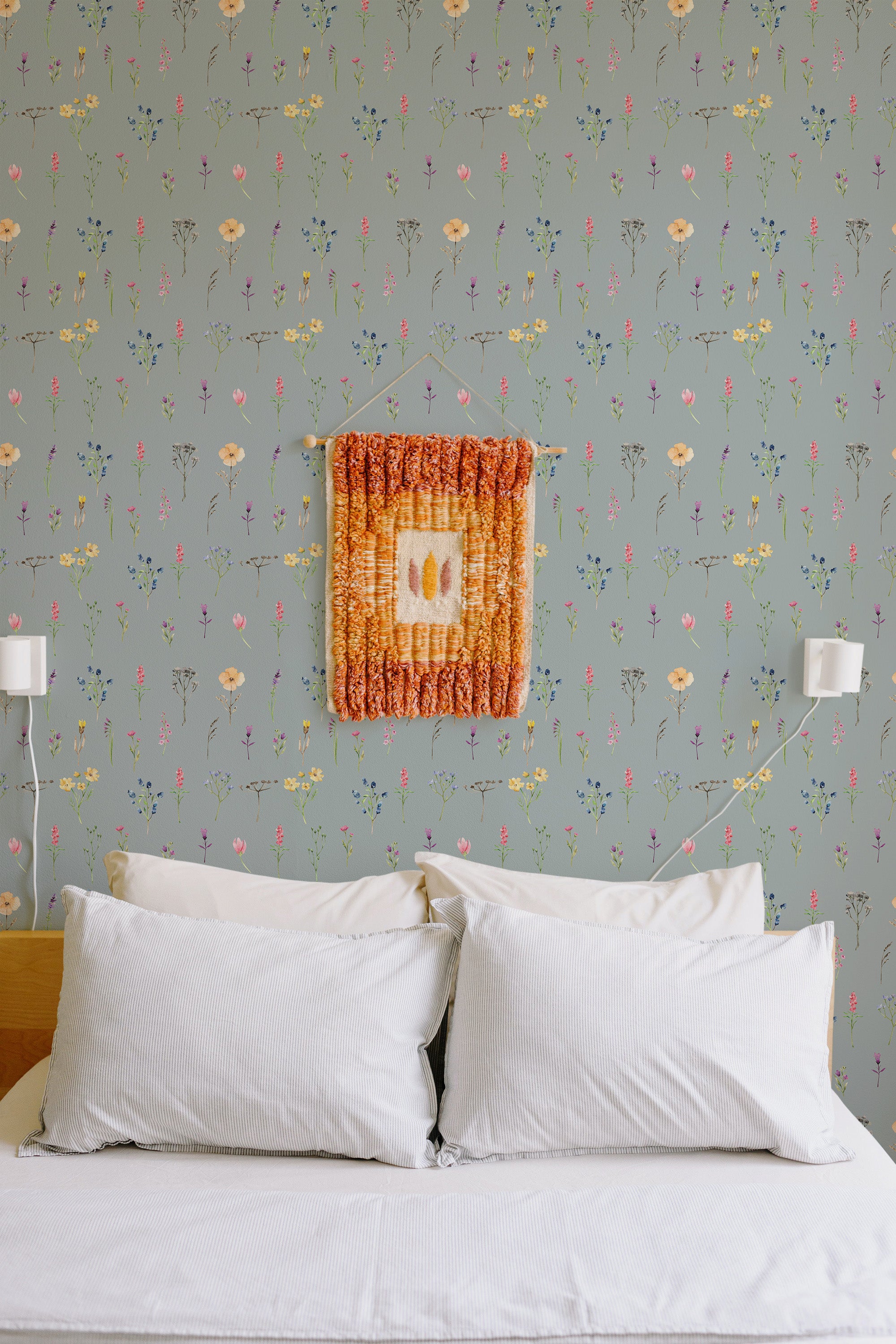 Self-adhesive wallpaper with a design of colorful wildflowers on a soft gray background, complementing the cozy, light-filled bedroom atmosphere.