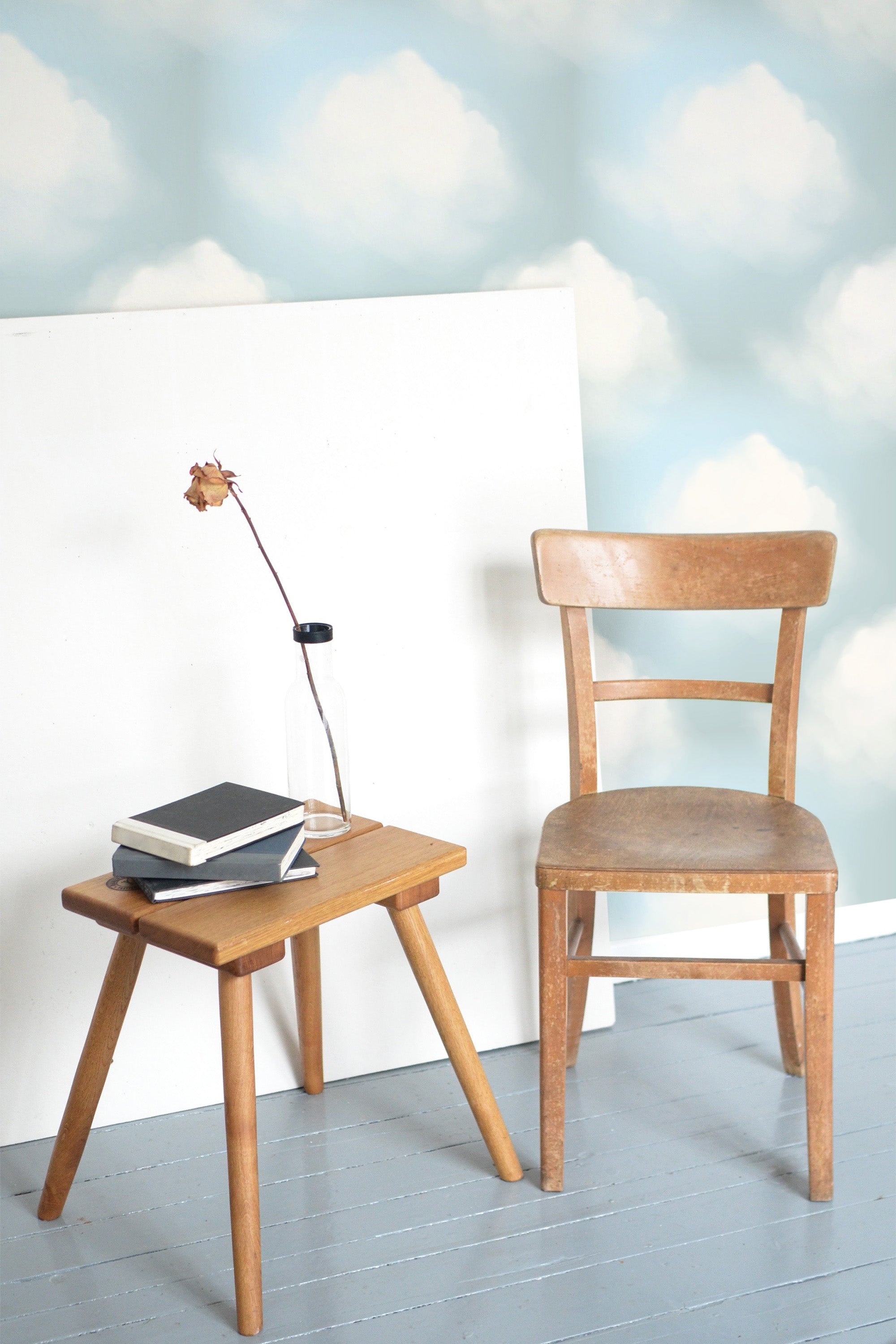 Self-adhesive Bay Clouds wallpaper with soft, fluffy white clouds floating against a pale blue sky background.