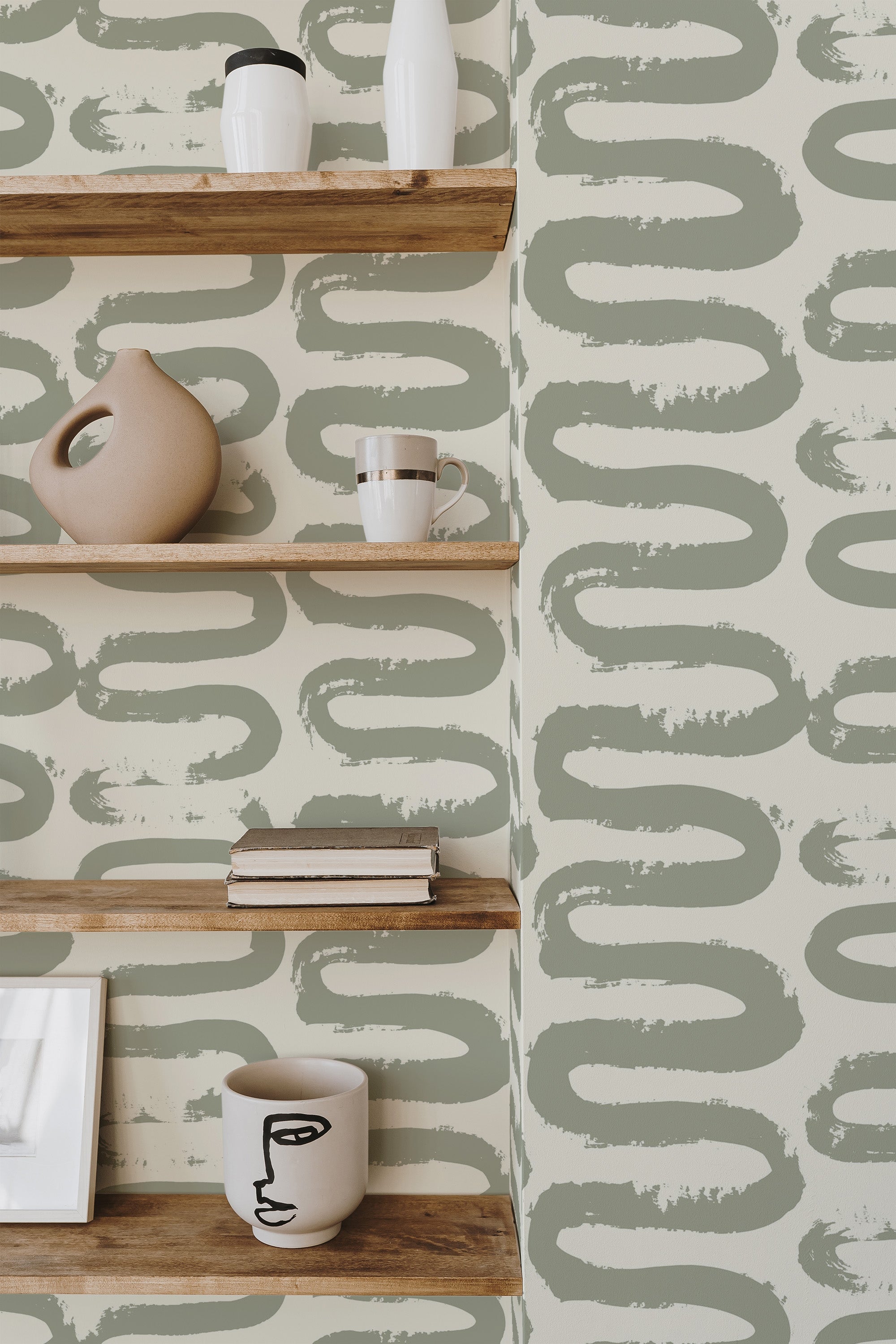 Self-adhesive wallpaper with a Wiggle brush lines design in green and beige hues, creating a fluid, artistic pattern on a light background, adding a modern and whimsical touch to the interior space.