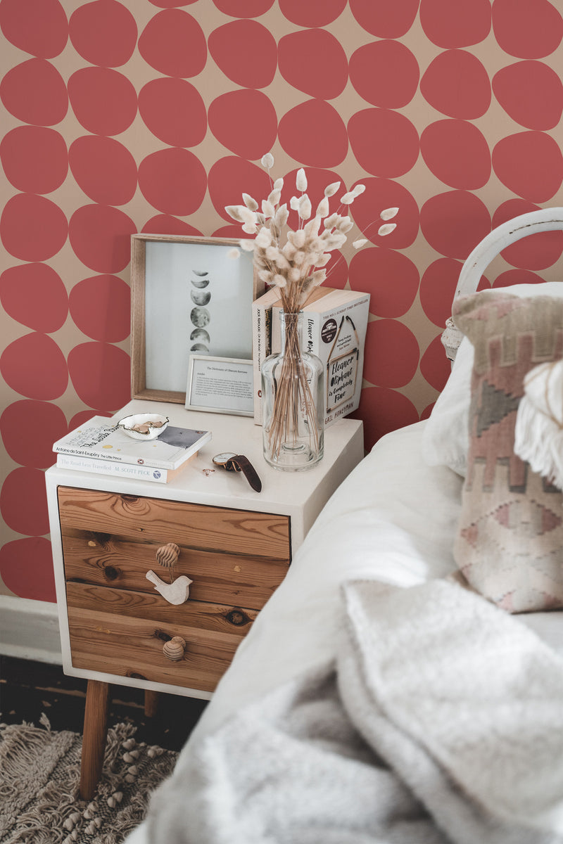 Self-adhesive wallpaper showing large circular patterns in shades of red against a beige background, creating a bold and modern geometric design that adds warmth and a stylish touch to the room's decor.