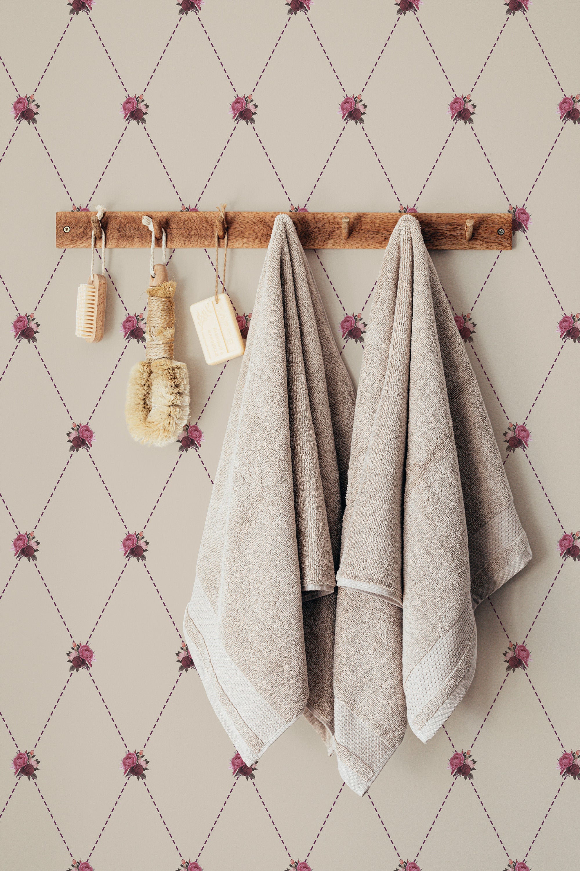 Self-adhesive wallpaper with a repeating vintage tiny rose pattern on a beige background, accentuated by hanging towels and wooden bathroom accessories.