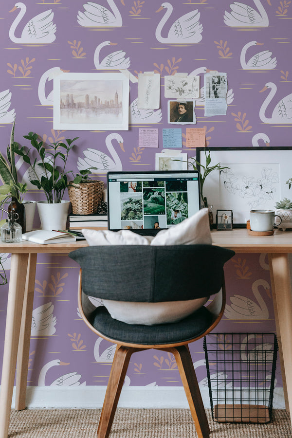 Self-adhesive purple wallpaper with elegant white swan motifs and subtle green leaf accents in a cozy workspace setting.