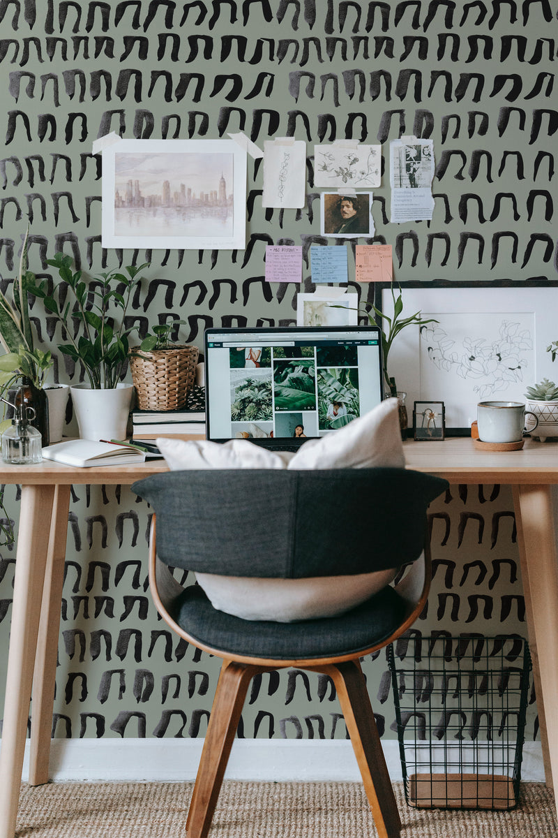 Self-adhesive Ink Doodle pattern wallpaper with abstract black brushstroke designs on white background in a stylish workspace setting.