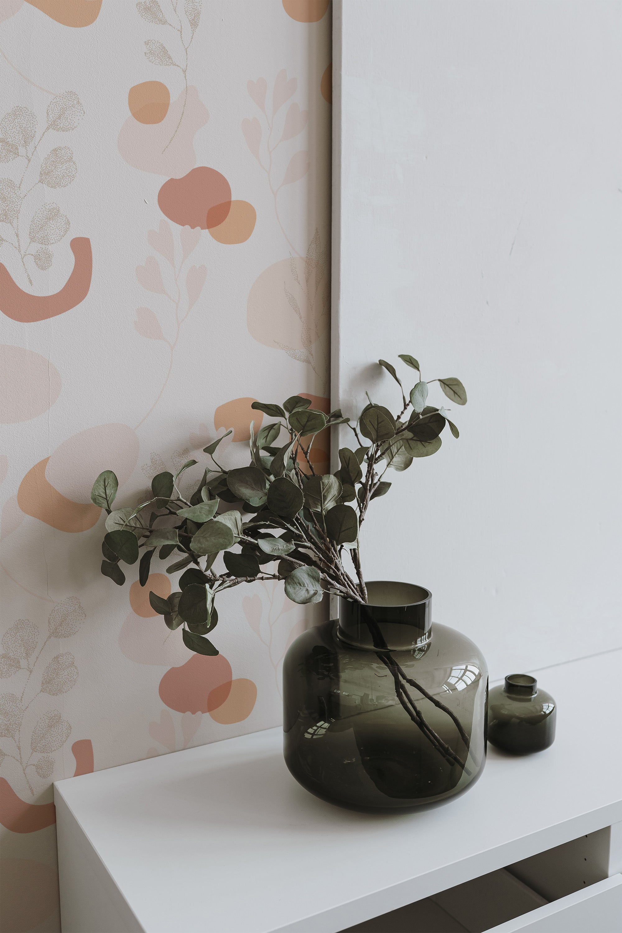 Self-adhesive neutral boho wallpaper with abstract pastel shapes and organic patterns on a light background, complementing a modern home decor with a botanical element on the side.