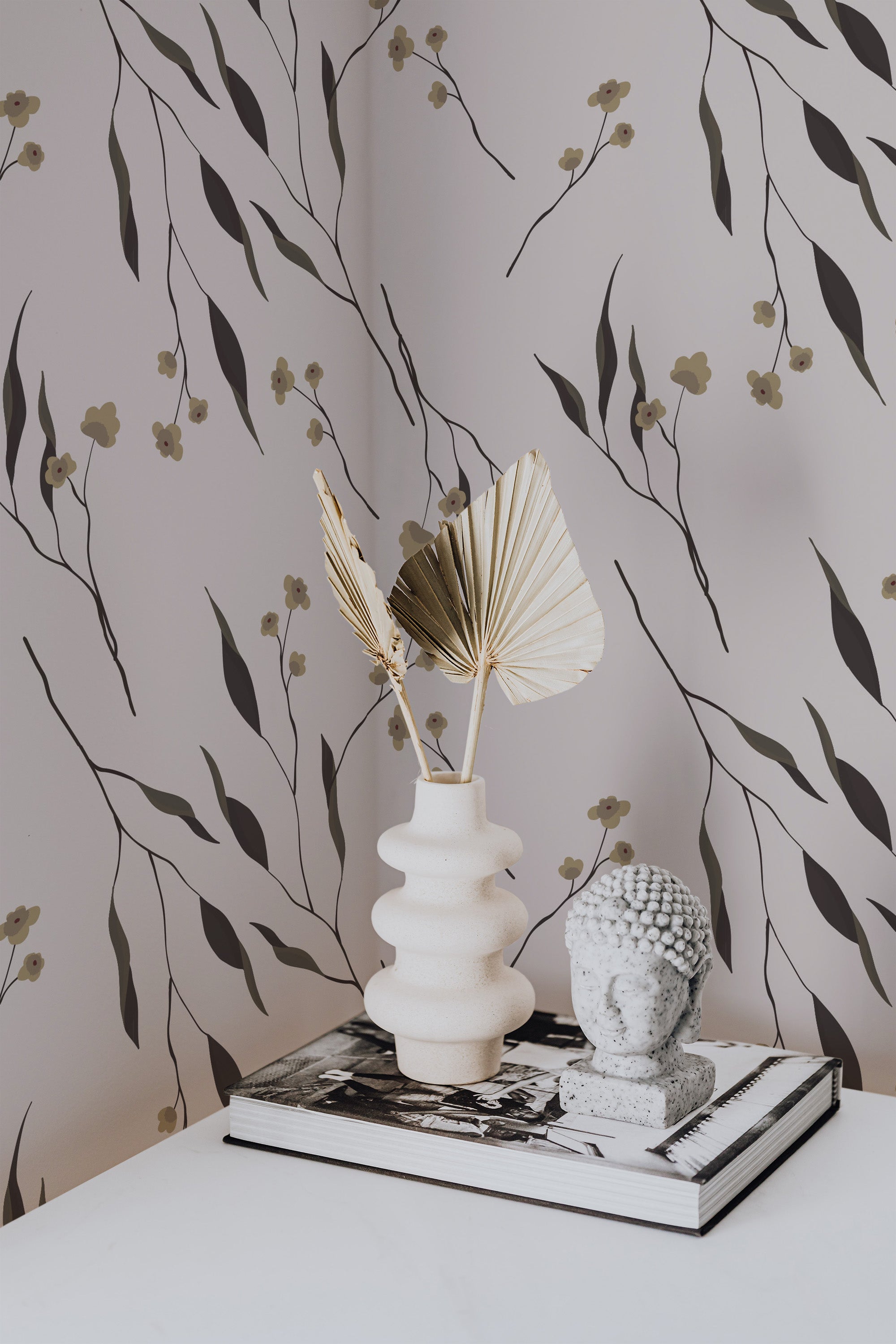 Self-adhesive wallpaper with a neutral delicate flower pattern, brown stems, and beige blooms on a pale background, accompanied by decorative items on a table.